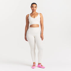 NikeSKIMS MATTE V-NECK BRA TOP | IVORY ON A MODEL 