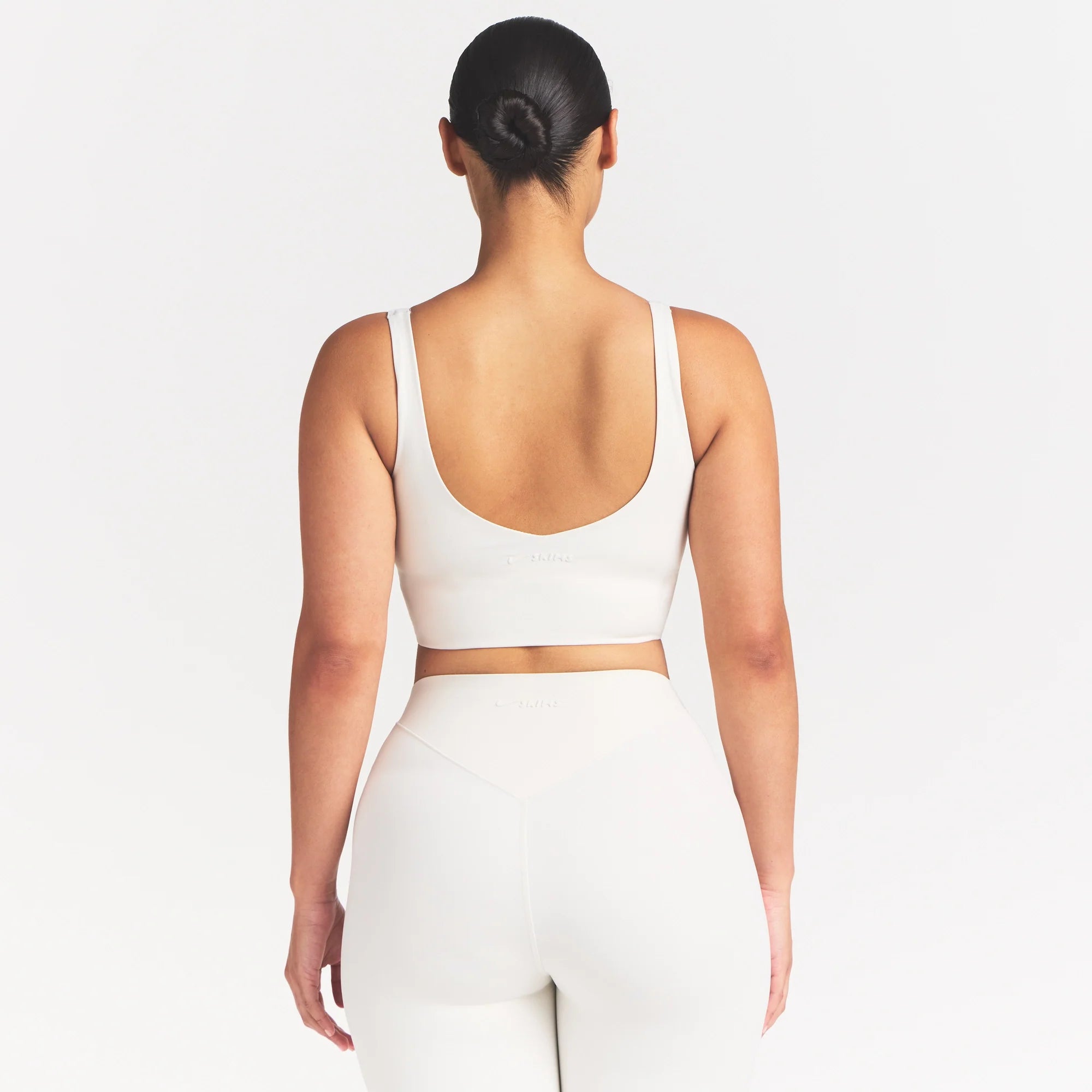 NikeSKIMS MATTE V-NECK BRA TOP | IVORY ON A MODEL 