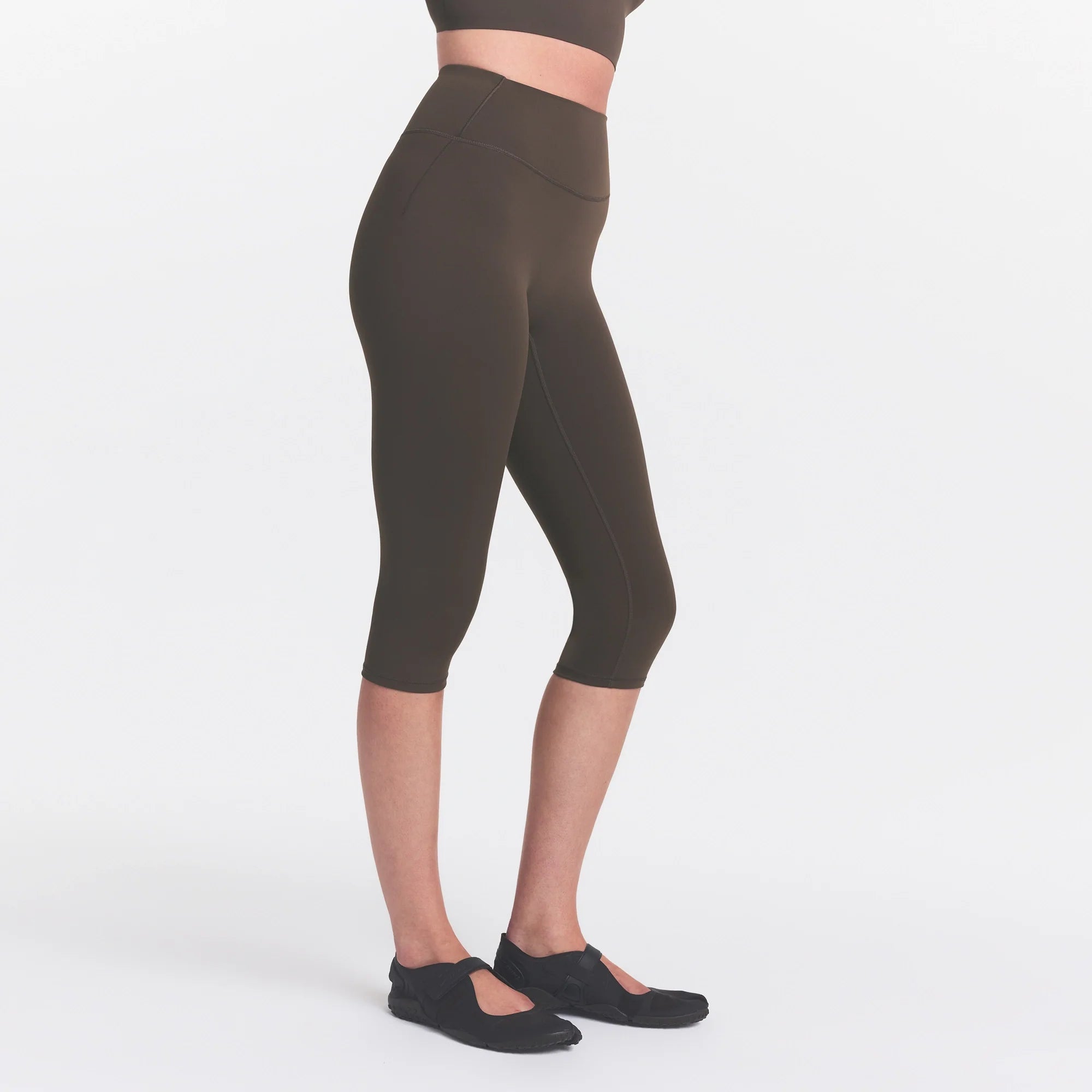 NikeSKIMS MATTE CROP 17" LEGGING | DARK SEPIA ON A MODEL FRONT VIEW @ | FOCUS: 0.0, 1.0, 0.9