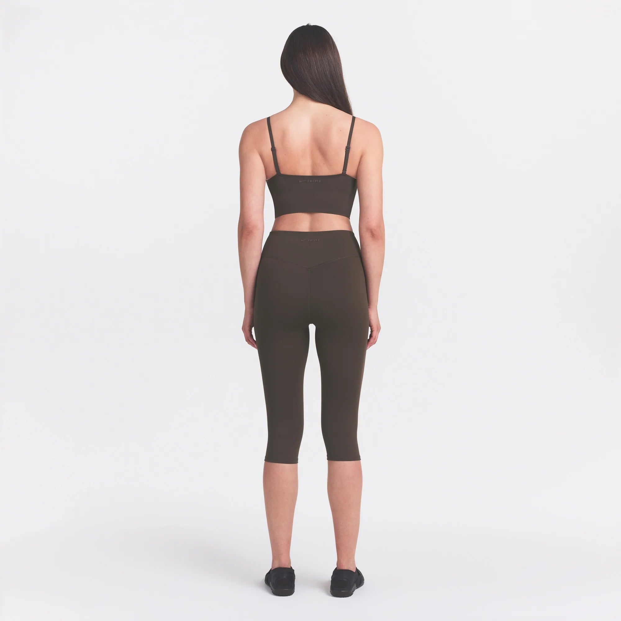 NikeSKIMS MATTE CROP 17" LEGGING | DARK SEPIA ON A MODEL FRONT VIEW @ | FOCUS: 0.0, 1.0, 0.9