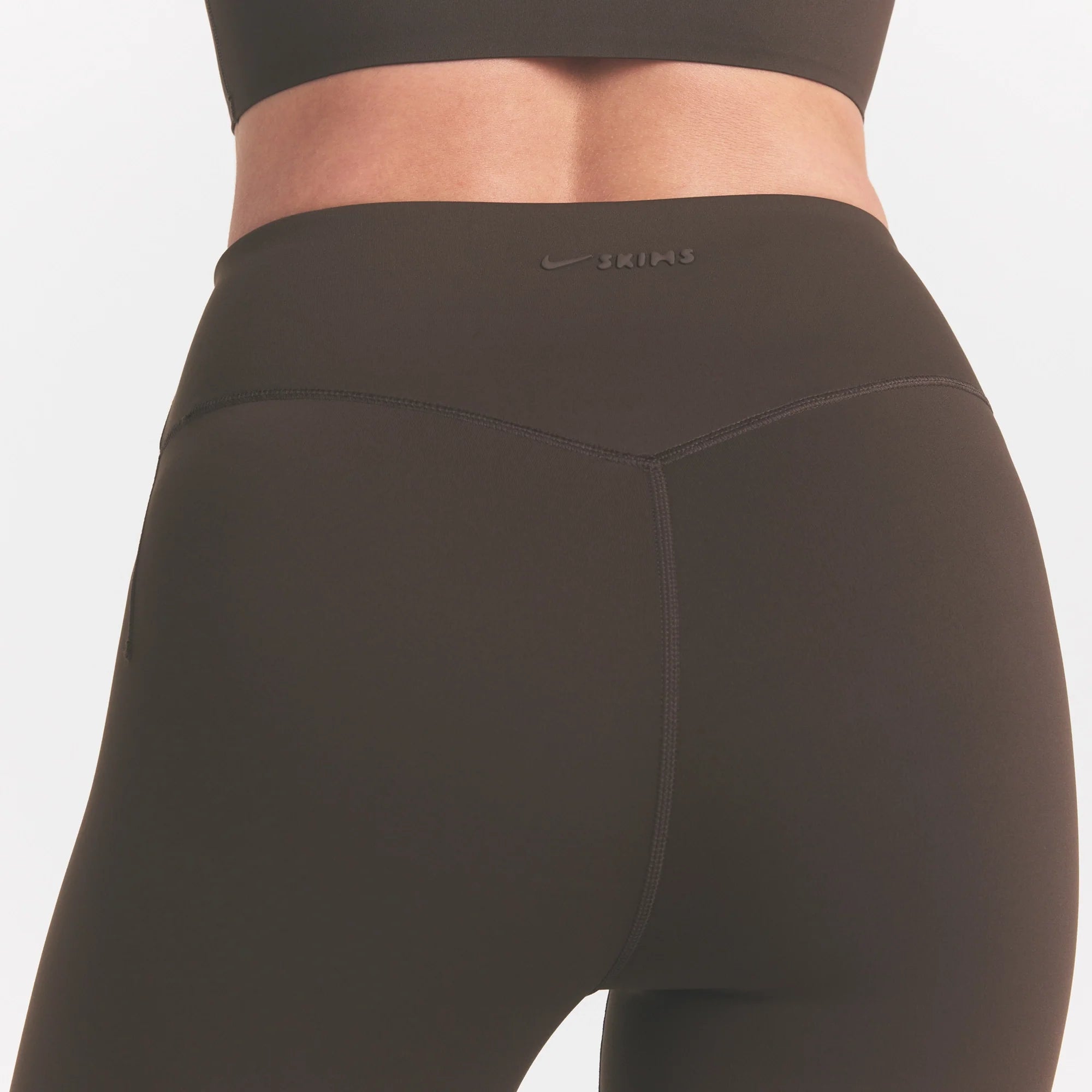 NikeSKIMS MATTE CROP 17" LEGGING | DARK SEPIA ON A MODEL FRONT VIEW @ | FOCUS: 0.0, 1.0, 0.9