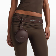 NikeSKIMS ACCESSORIES HARDSHELL ROUND CASE | PHOENIX ON A MODEL FRONT VIEW @ | FOCUS: 0.0, 1.0, 0.9