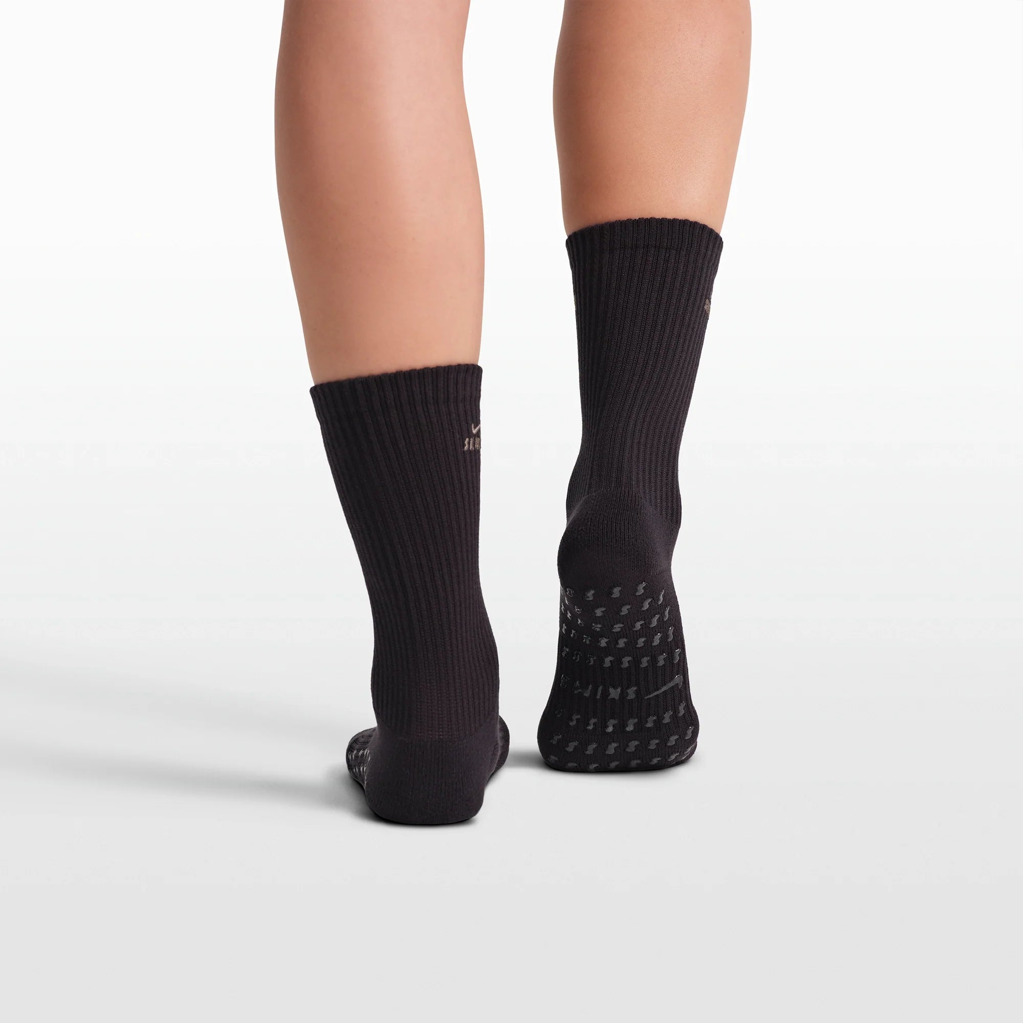 NikeSKIMS ACCESSORIES DRI-FIT PILATES GRIP CREW SOCK | OBSIDIAN FLAT ON A WHITE BACKGROUND