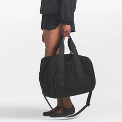 NikeSKIMS ACCESSORIES PUFFER GYM BAG | OBSIDIAN ON A MODEL FRONT VIEW @ | FOCUS: 0.0, 1.0, 0.9
