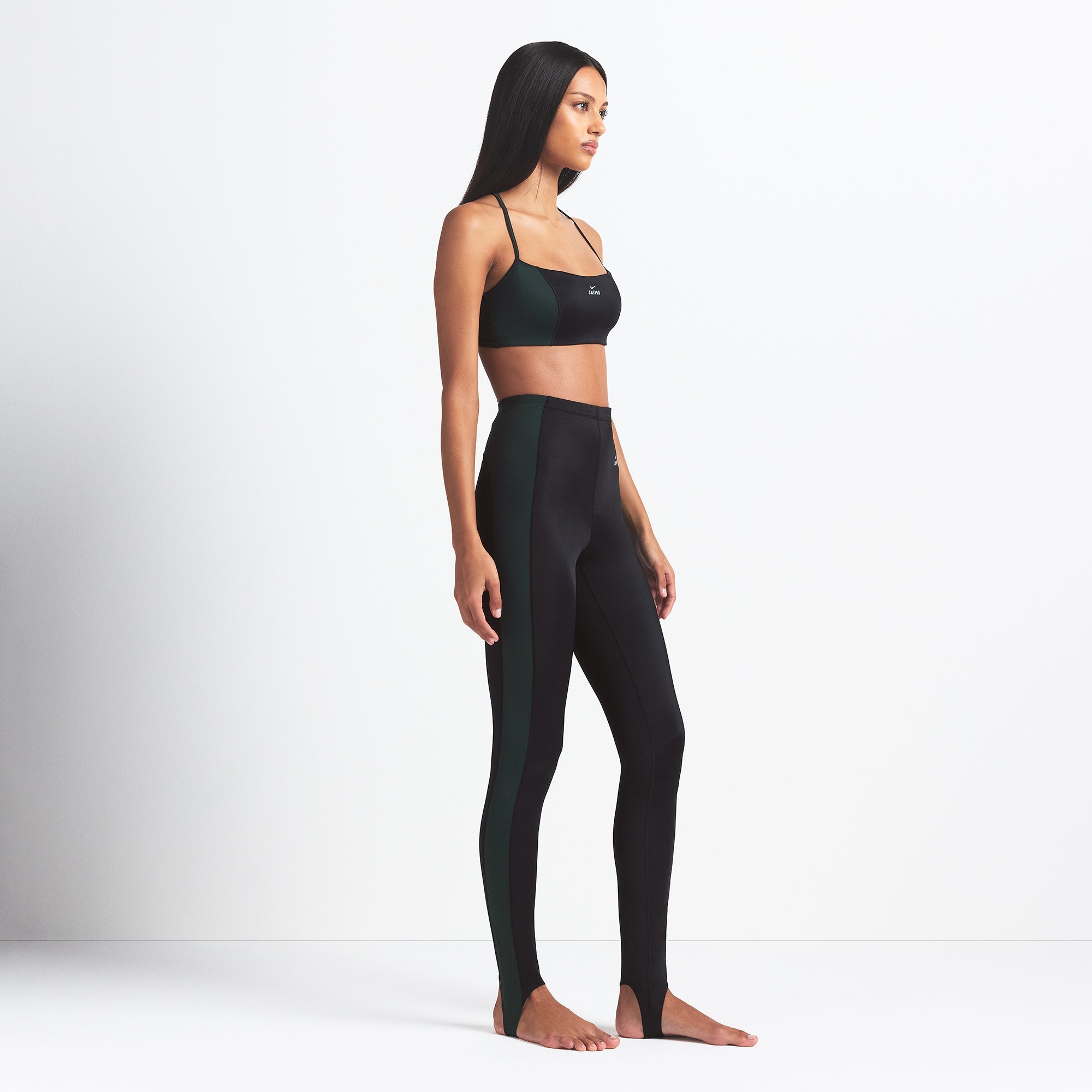 NikeSKIMS SHINE DRAWCORD STIRRUP 26" LEGGING | OBSIDIAN AND DARK TEAL ON A MODEL SIDE VIEW @ | FOCUS: 0.0, 1.0, 0.9