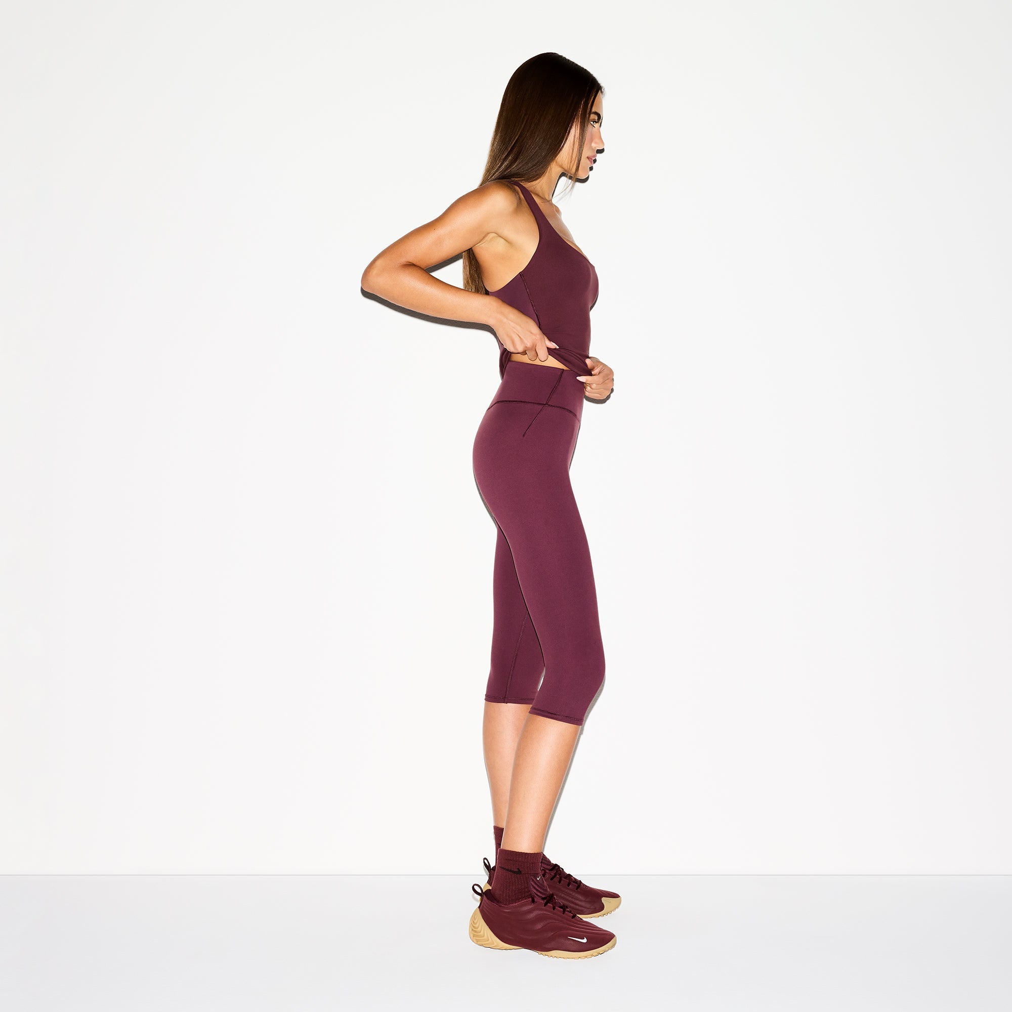 NikeSKIMS MATTE CROP 17" LEGGING | CURRANT ON A MODEL SIDE VIEW @ | FOCUS: 0.0, 1.0, 0.9