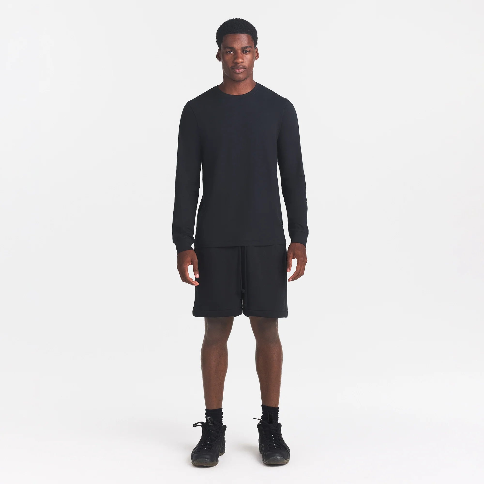 SKIMS COTTON MENS CLASSIC LONG SLEEVE T-SHIRT | ONYX ON A MODEL FRONT VIEW