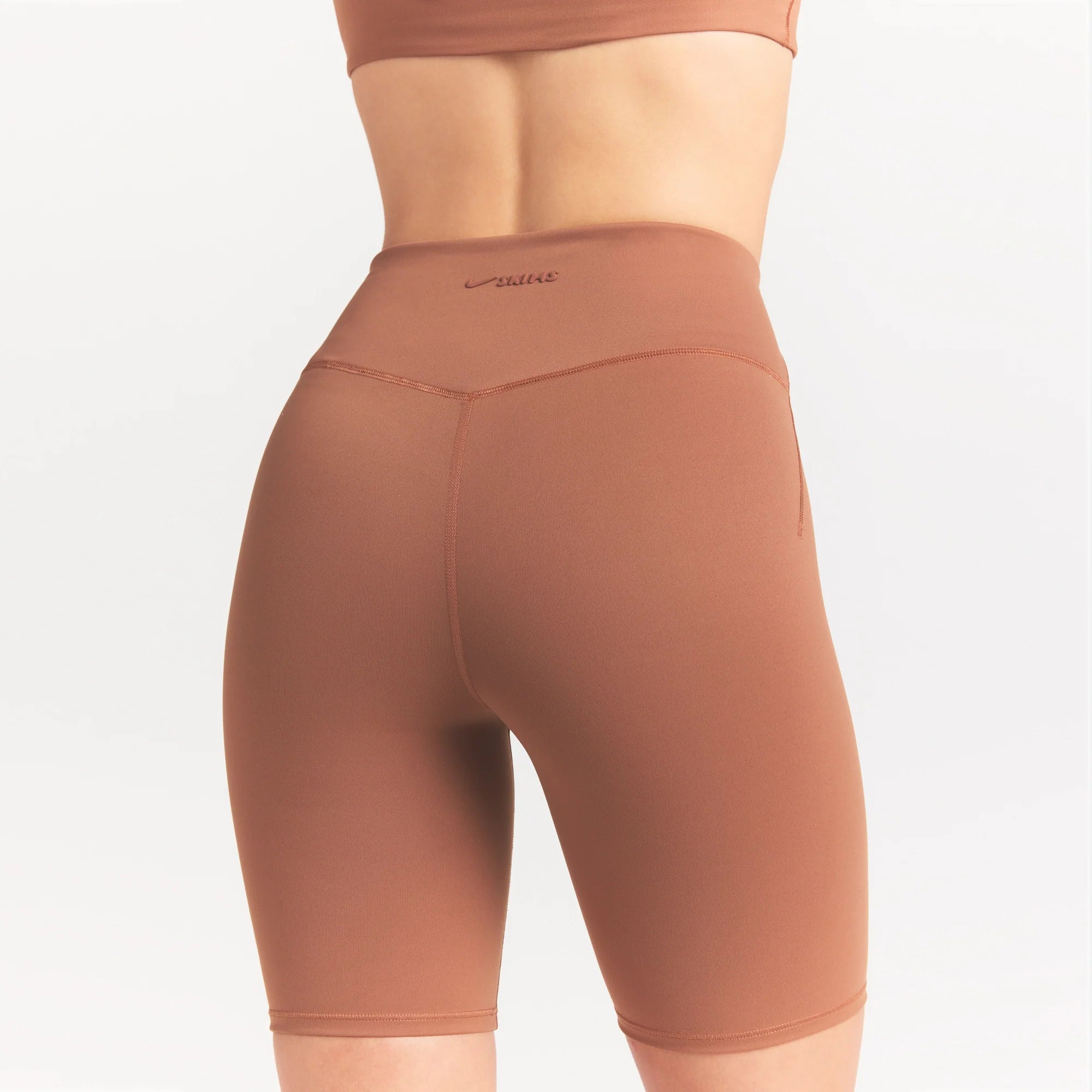 NikeSKIMS MATTE 7" BIKER SHORT | CAROB BROWN ON A MODEL SIDE VIEW @ | FOCUS: 0.0, 1.0, 0.9