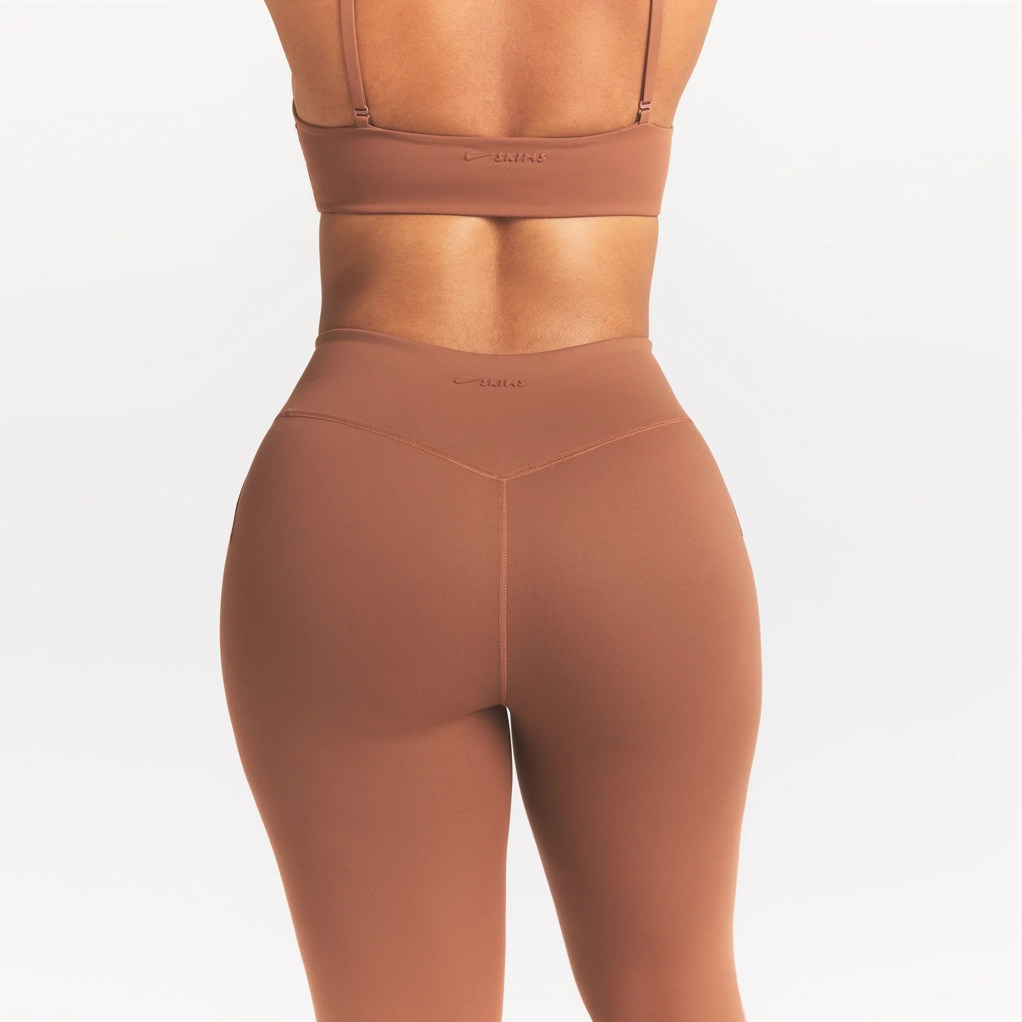 NikeSKIMS MATTE 26" LEGGING | CAROB BROWN ON A MODEL SIDE VIEW @ | FOCUS: 0.0, 1.0, 0.9