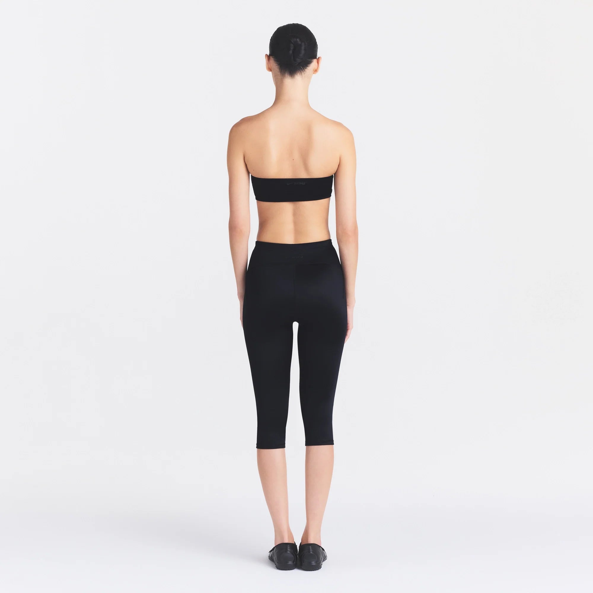 NikeSKIMS SATIN SHINE CAPRI 17" LEGGING | OBSIDIAN ON A MODEL FRONT VIEW