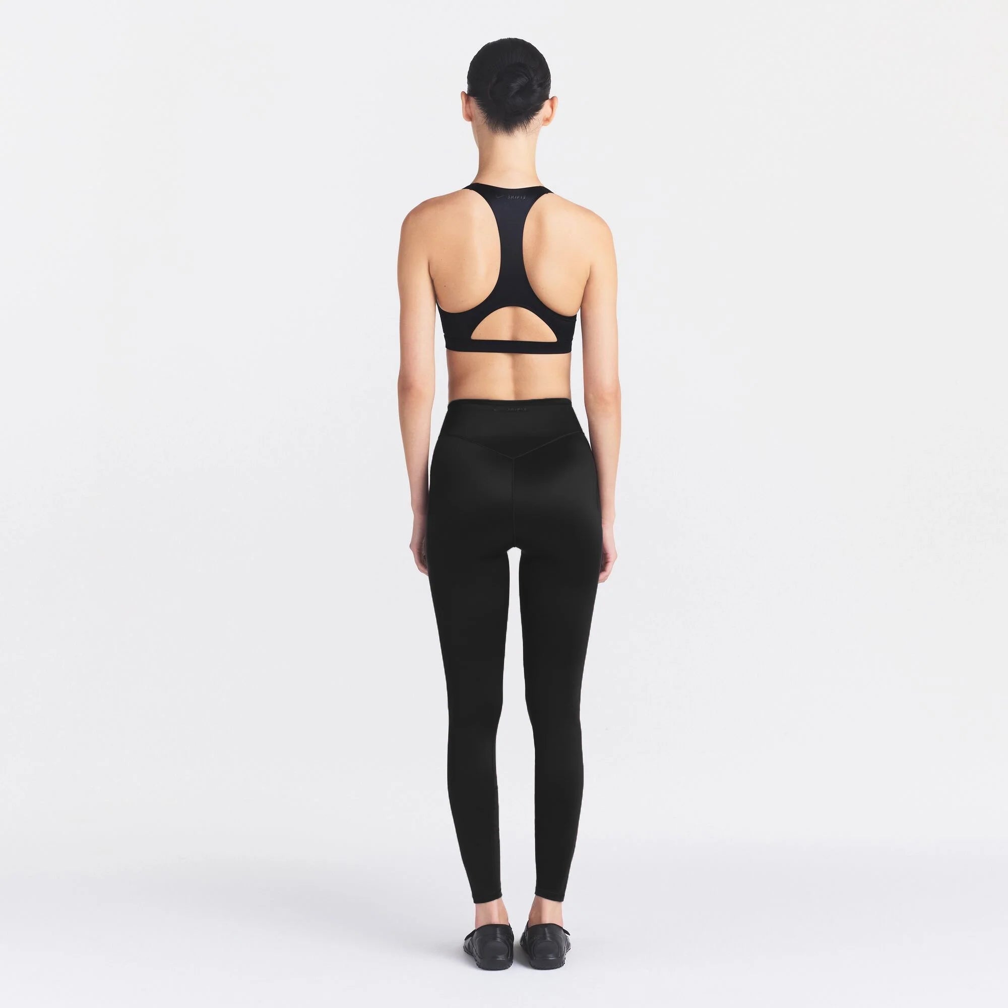NikeSKIMS SATIN SHINE BONDED WAIST 26" LEGGING | OBSIDIAN ON A MODEL FRONT VIEW