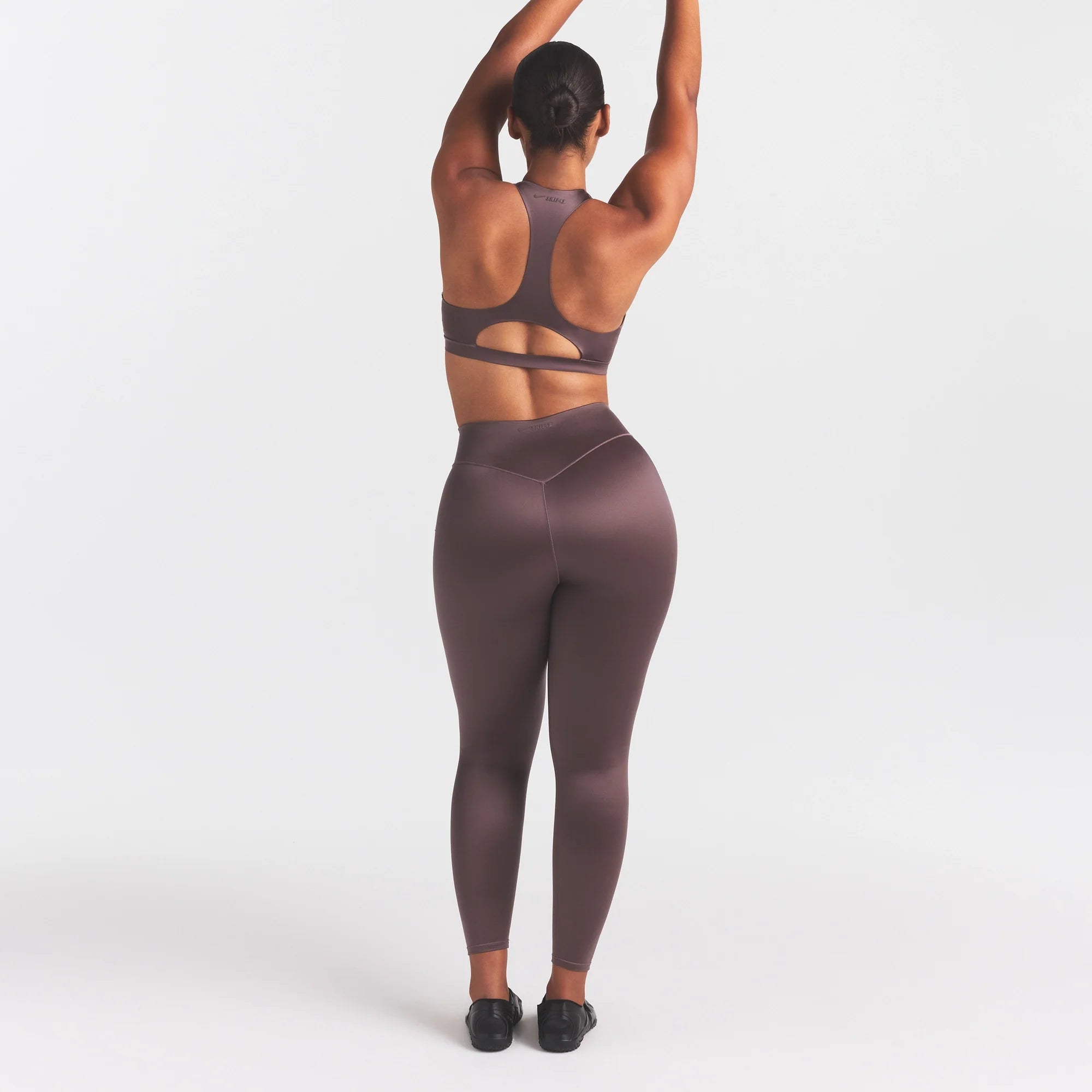 NikeSKIMS SATIN SHINE BONDED WAIST 26" LEGGING | RESIN ON A MODEL FRONT VIEW