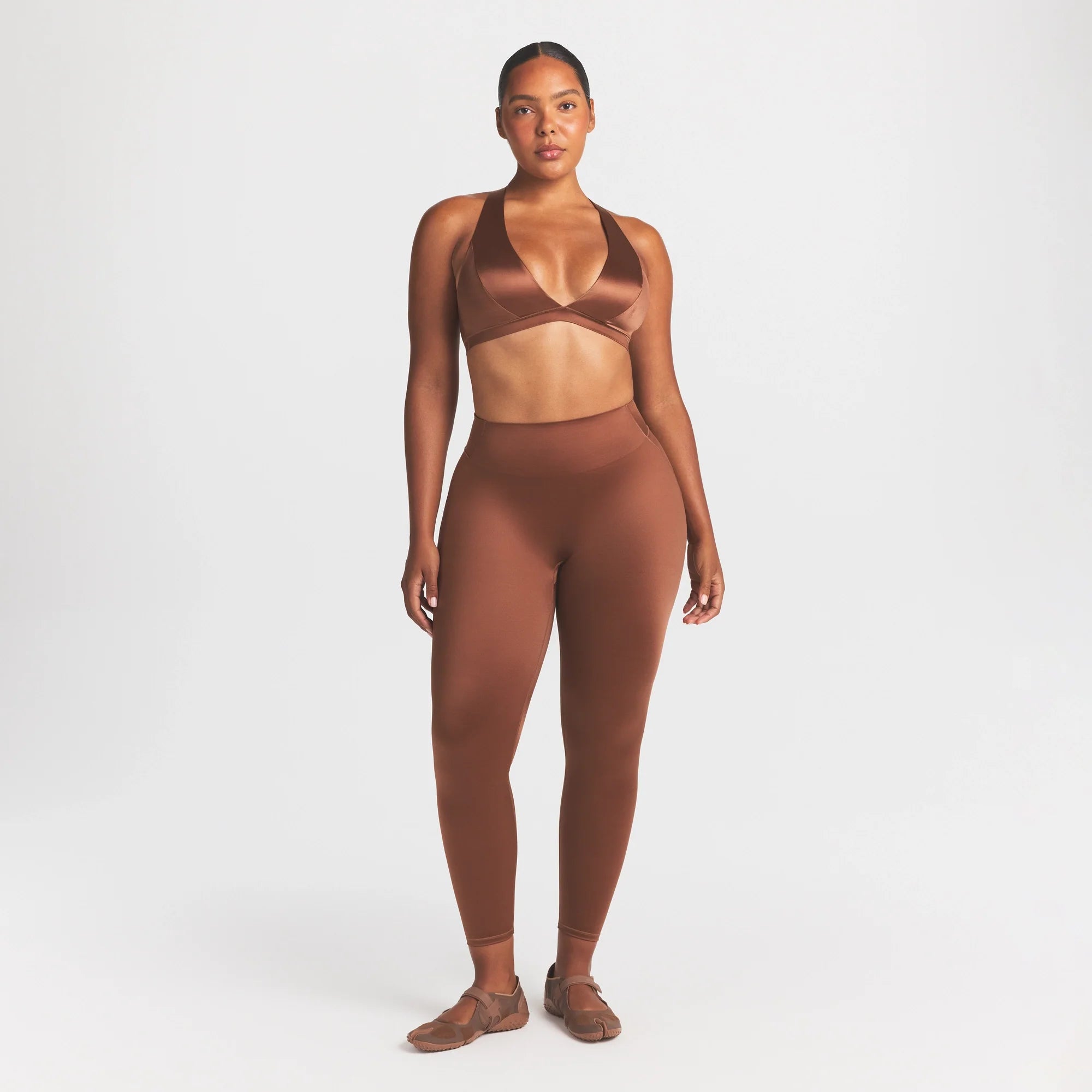 NikeSKIMS SATIN SHINE BONDED WAIST 26" LEGGING | CAROB BROWN ON A MODEL FRONT VIEW @ | FOCUS: 0.0, 1.0, 0.9
