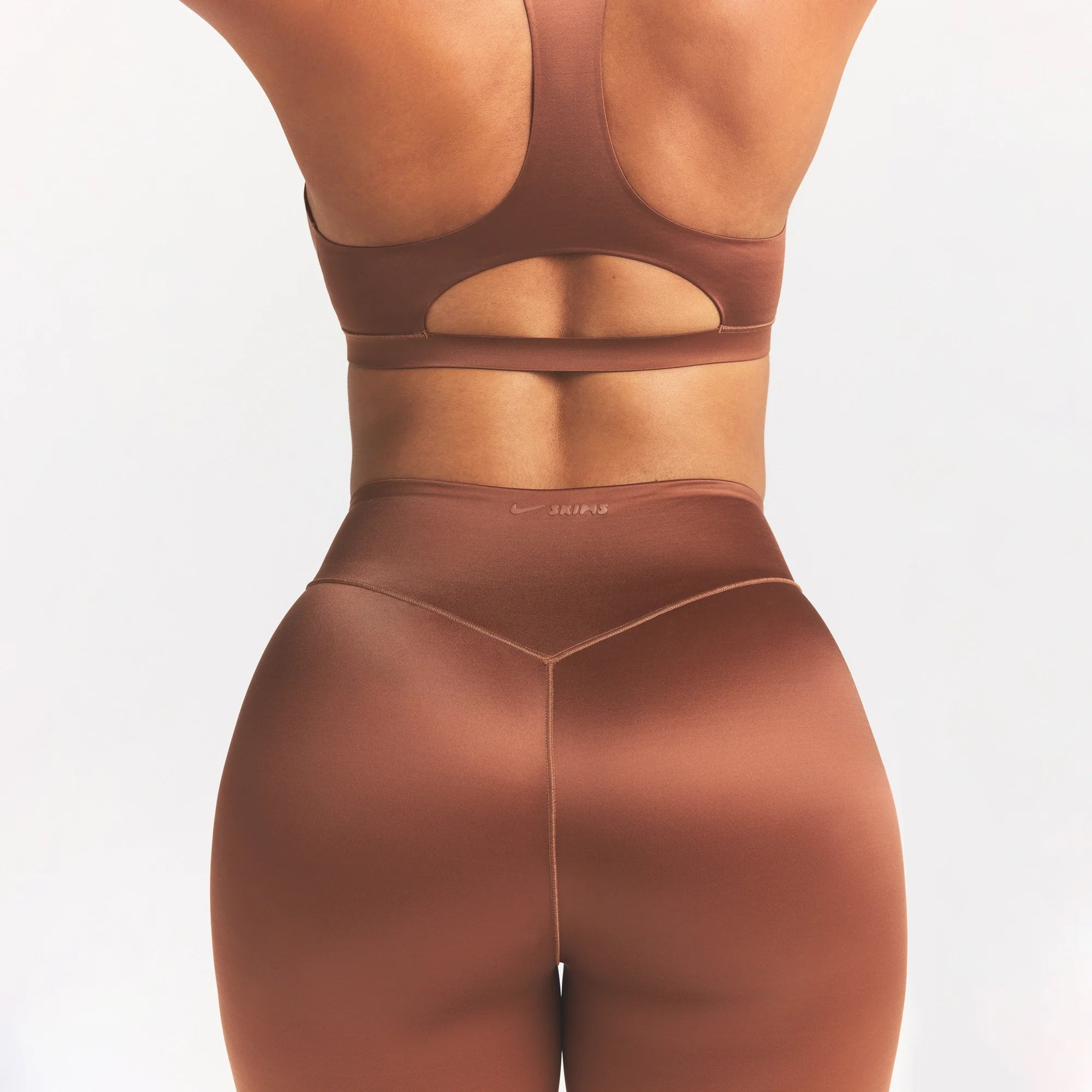NikeSKIMS SATIN SHINE BONDED WAIST 26" LEGGING | CAROB BROWN ON A MODEL SIDE VIEW @ | FOCUS: 0.0, 1.0, 0.9