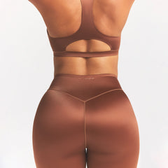 NikeSKIMS SATIN SHINE BONDED WAIST 26" LEGGING | CAROB BROWN ON A MODEL SIDE VIEW @ | FOCUS: 0.0, 1.0, 0.9