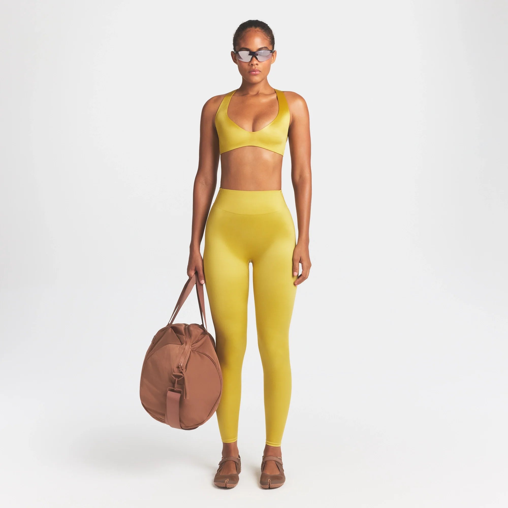 NikeSKIMS SATIN SHINE BONDED WAIST 26" LEGGING | CITRINE ON A MODEL FRONT VIEW @ | FOCUS: 0.0, 1.0, 0.9