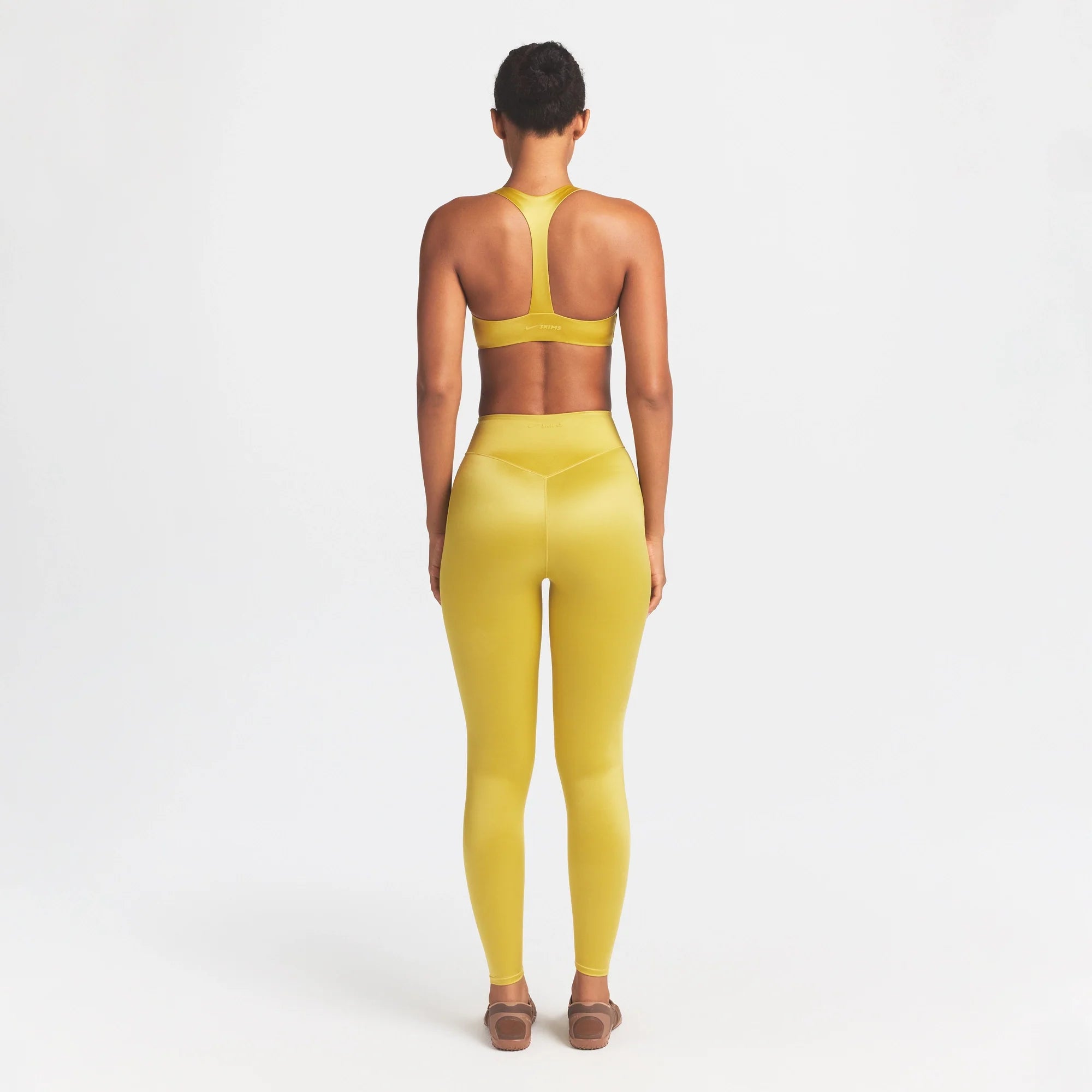 NikeSKIMS SATIN SHINE BONDED WAIST 26" LEGGING | CITRINE ON A MODEL FRONT VIEW