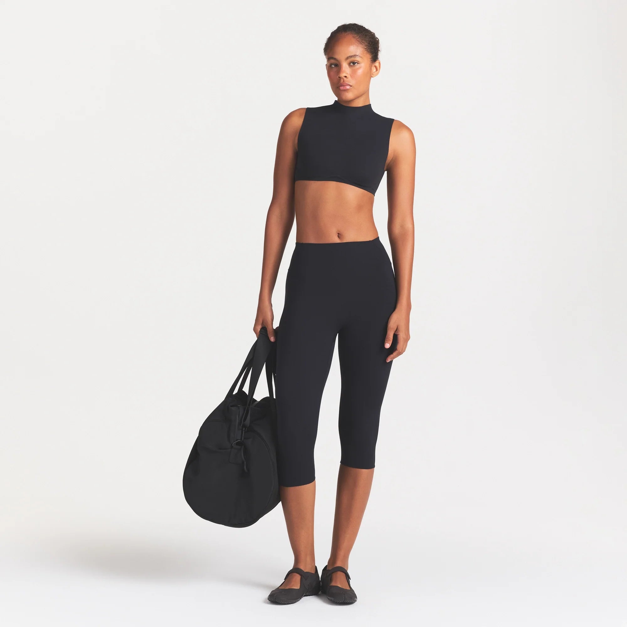 NikeSKIMS STUDIO STRETCH 17" CAPRI LEGGING | OBSIDIAN ON A MODEL FRONT VIEW @ | FOCUS: 0.0, 1.0, 0.9