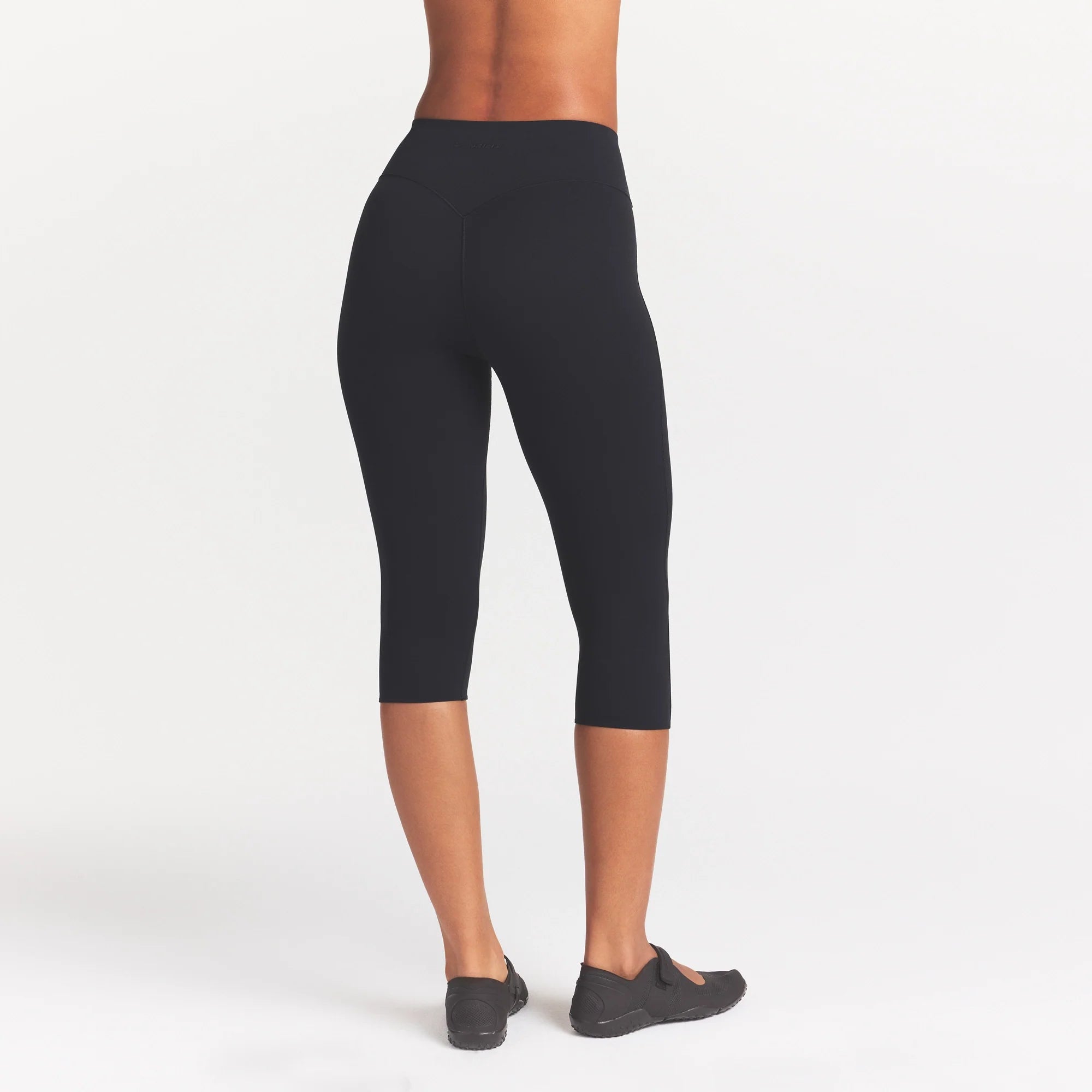 NikeSKIMS STUDIO STRETCH 17" CAPRI LEGGING | OBSIDIAN ON A MODEL SIDE VIEW @ | FOCUS: 0.0, 1.0, 0.9