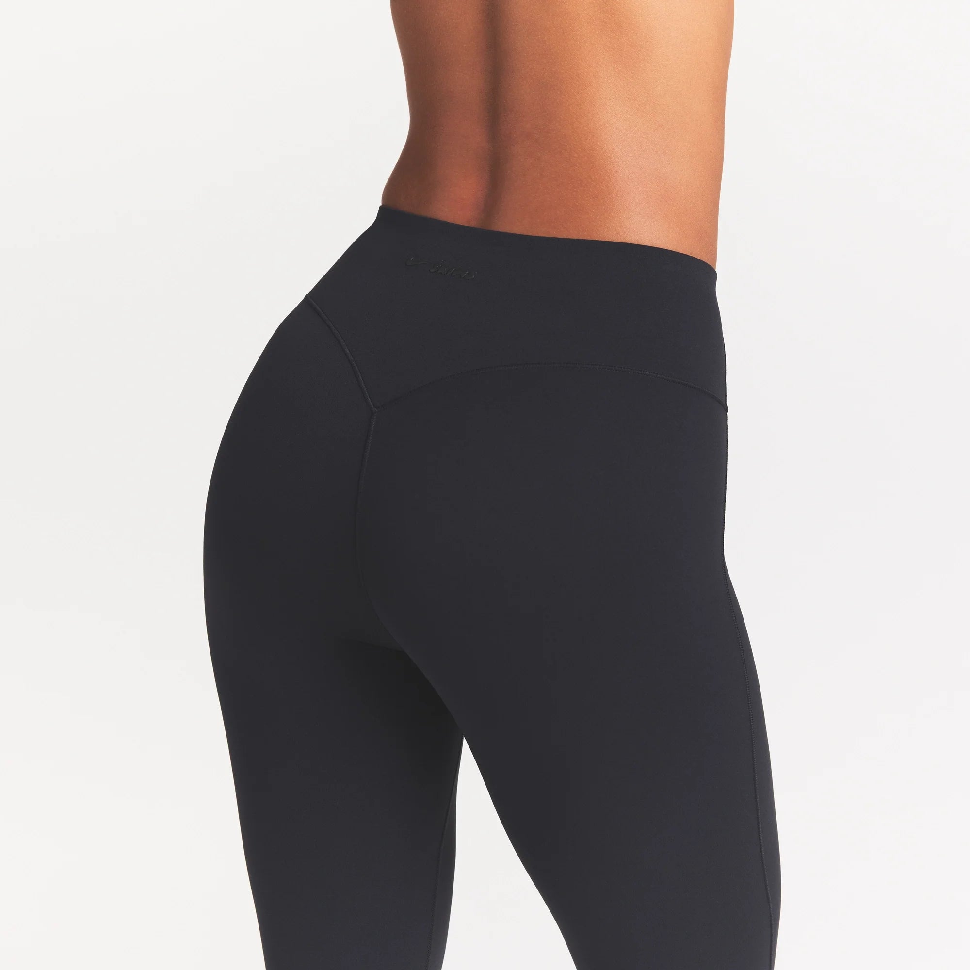 NikeSKIMS STUDIO STRETCH 17" CAPRI LEGGING | OBSIDIAN ON A MODEL SIDE VIEW