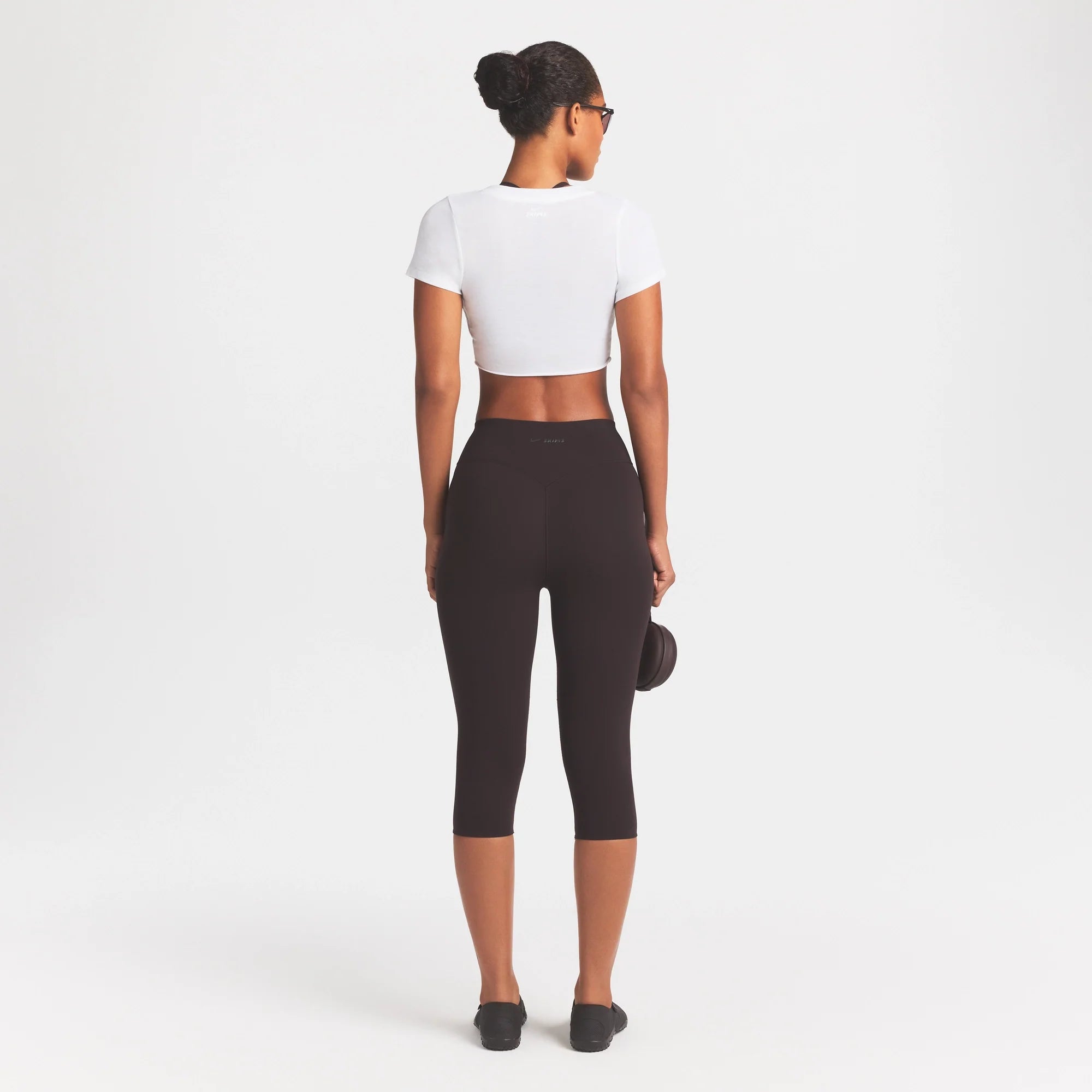 NikeSKIMS STUDIO STRETCH 17" CAPRI LEGGING | DARK ROAST/(NSKMDR) ON A MODEL FRONT VIEW | FOCUS: 0.0, 1.0, 0.9