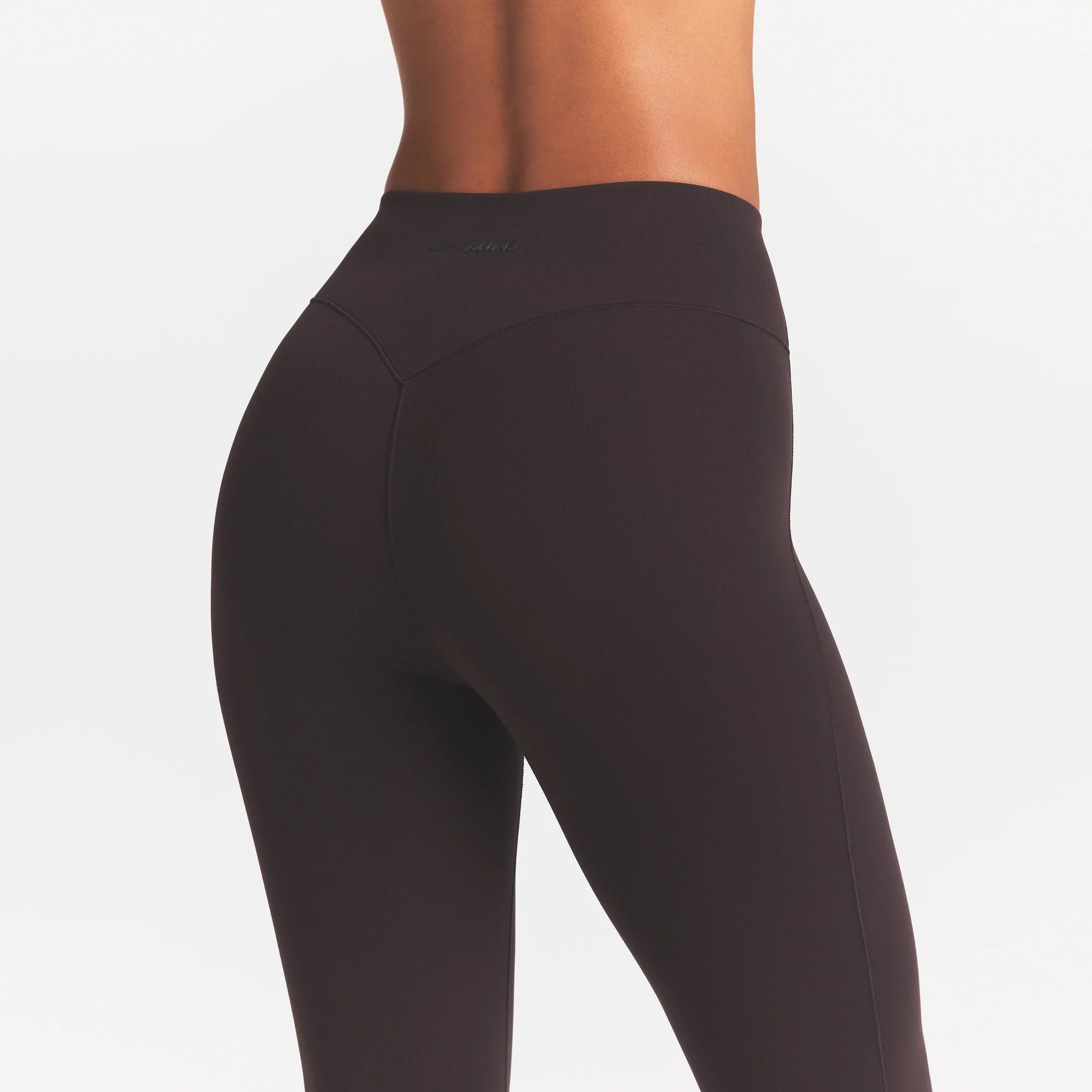 NikeSKIMS STUDIO STRETCH 17" CAPRI LEGGING | DARK ROAST/(NSKMDR) ON A MODEL SIDE VIEW @ | FOCUS: 0.0, 1.0, 0.9