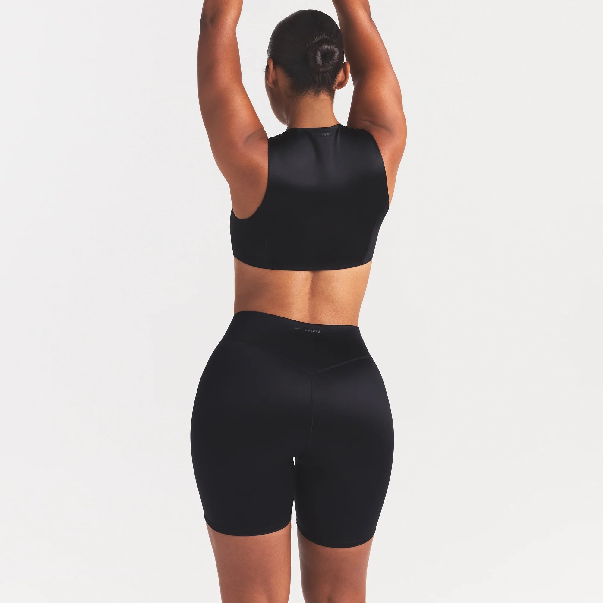 NikeSKIMS SATIN SHINE BONDED WAIST 7" BIKER SHORT | OBSIDIAN ON A MODEL SIDE VIEW