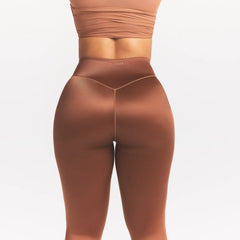 NikeSKIMS SATIN SHINE BONDED WAIST 29" LEGGING | CAROB BROWN ON A MODEL SIDE VIEW @ | FOCUS: 0.0, 1.0, 0.9