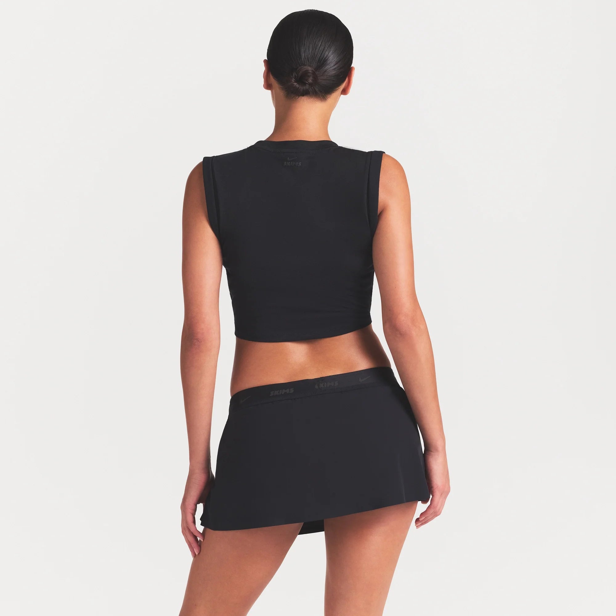 NikeSKIMS STRETCH NYLON SKORT | OBSIDIAN ON A MODEL SIDE VIEW