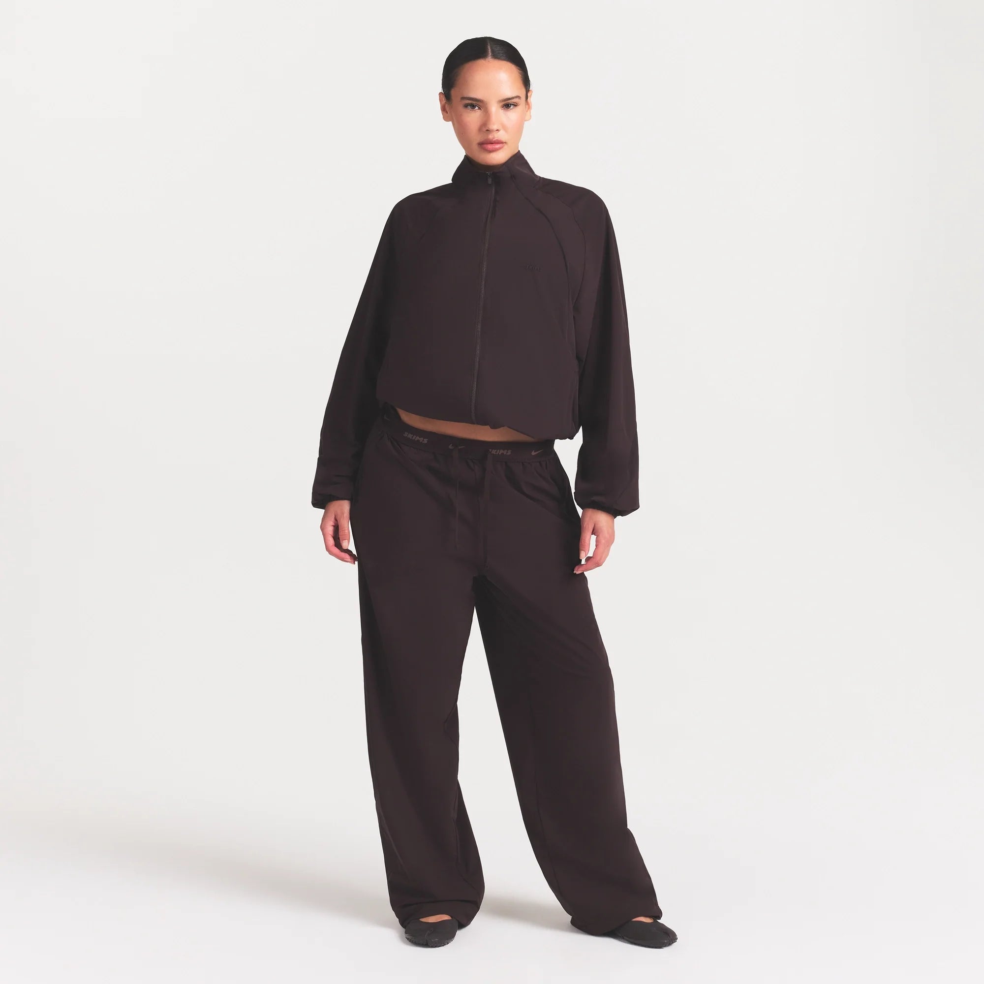NikeSKIMS STRETCH NYLON OVERSIZED PANT | DARK ROAST ON A MODEL FRONT VIEW @ | FOCUS: 0.0, 1.0, 0.9