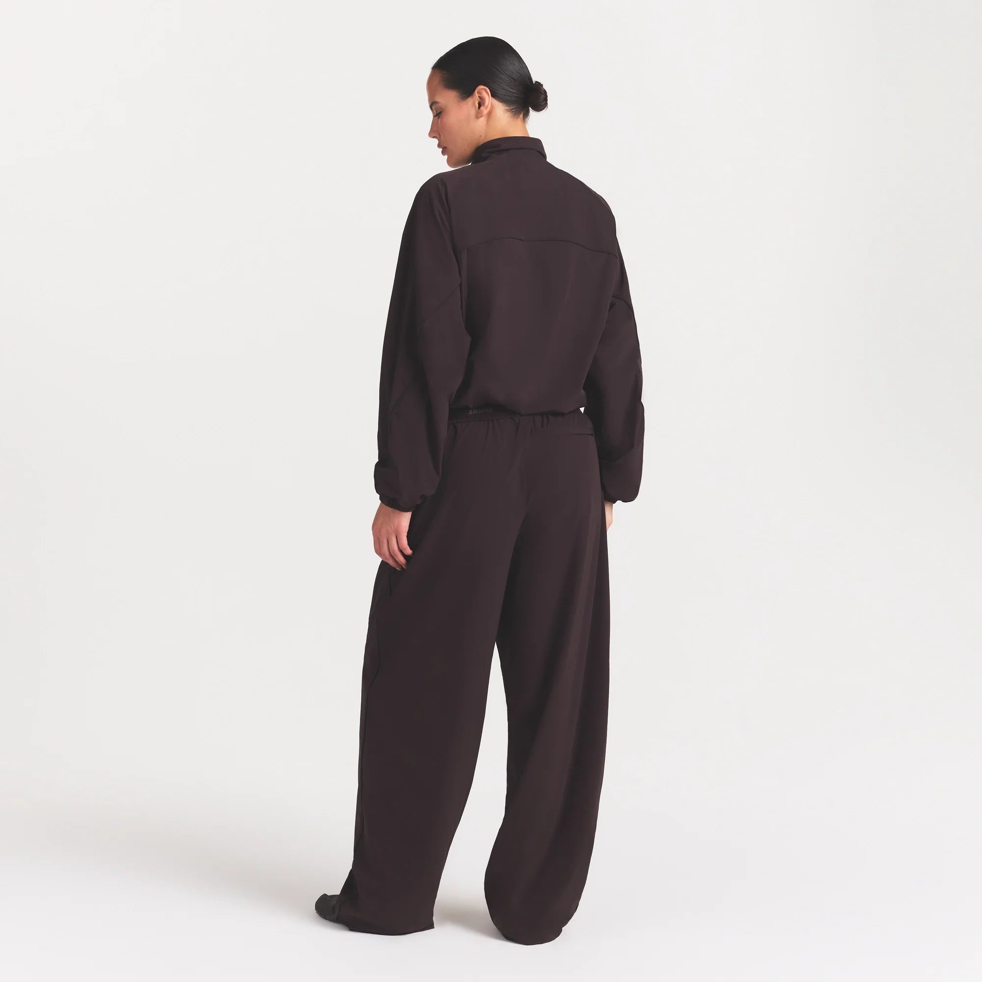 NikeSKIMS STRETCH NYLON OVERSIZED PANT | DARK ROAST ON A MODEL FRONT VIEW @ | FOCUS: 0.0, 1.0, 0.9