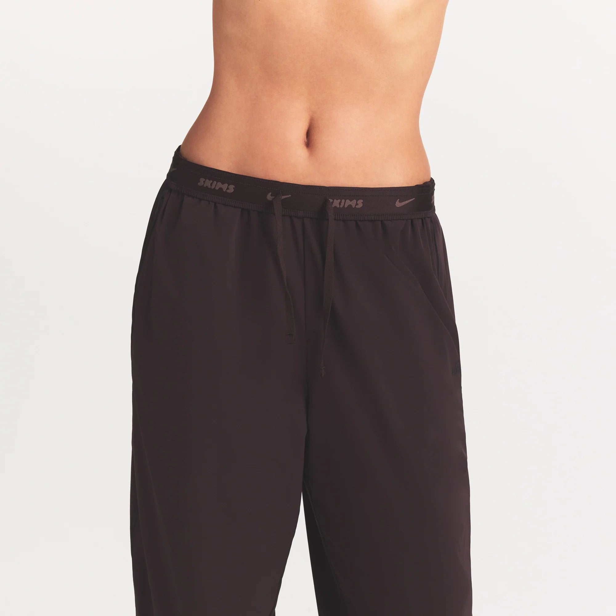 NikeSKIMS STRETCH NYLON OVERSIZED PANT | DARK ROAST ON A MODEL SIDE VIEW @ | FOCUS: 0.0, 1.0, 0.9