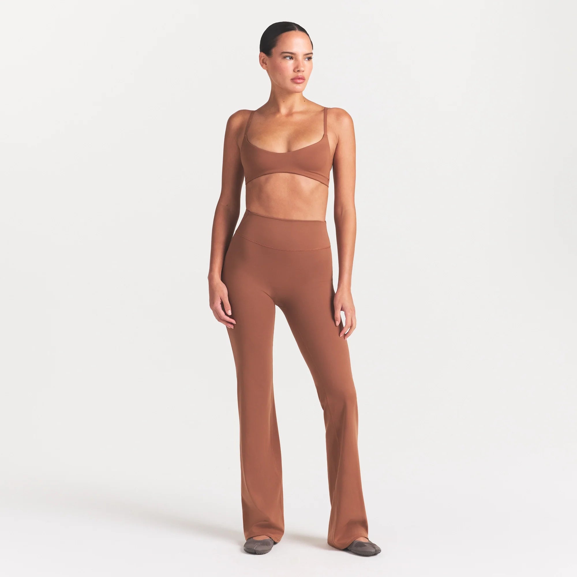 NikeSKIMS MATTE SLIM FLARE LEGGING | CAROB BROWN ON A MODEL FRONT VIEW @ | FOCUS: 0.0, 1.0, 0.9
