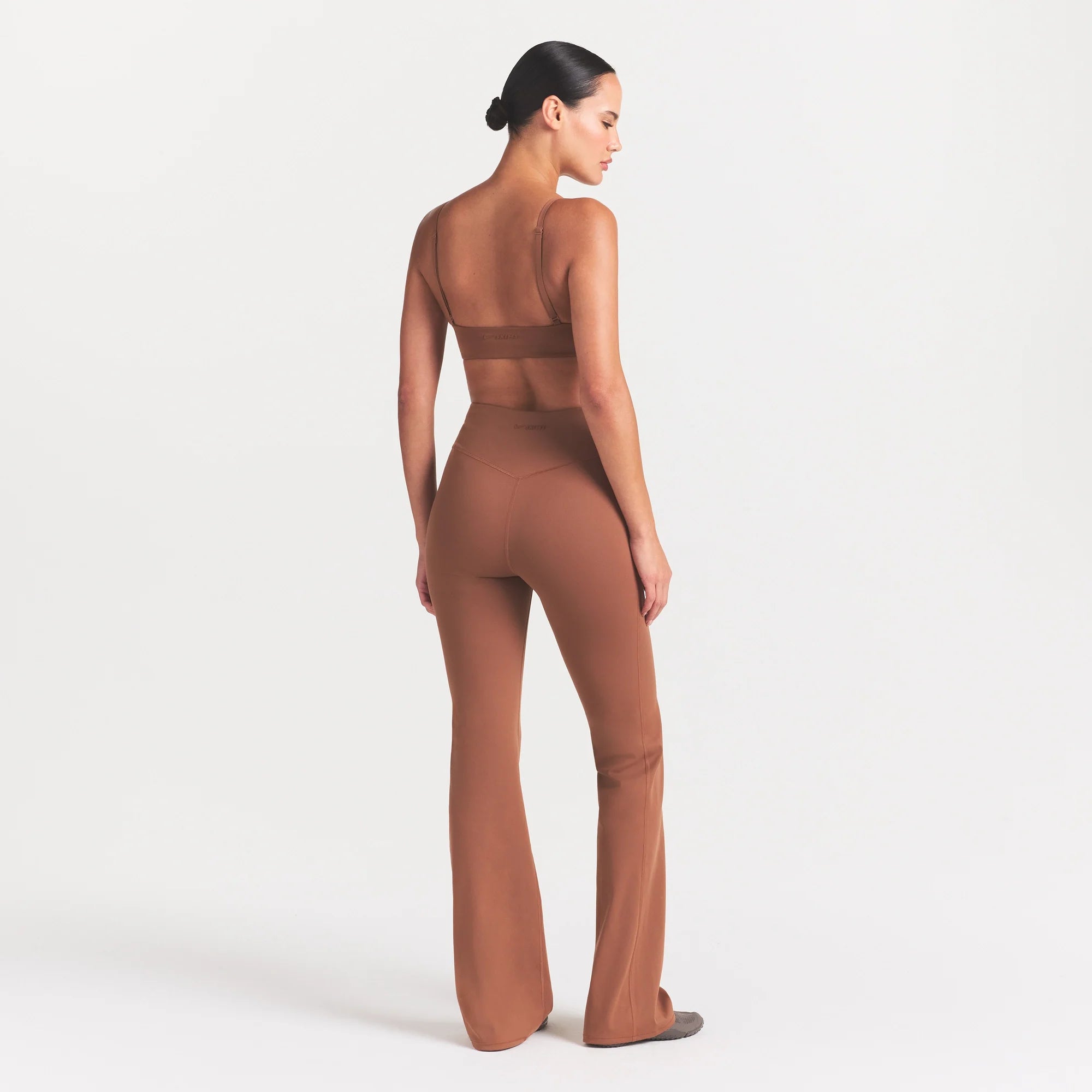 NikeSKIMS MATTE SLIM FLARE LEGGING | CAROB BROWN ON A MODEL FRONT VIEW @ | FOCUS: 0.0, 1.0, 0.9