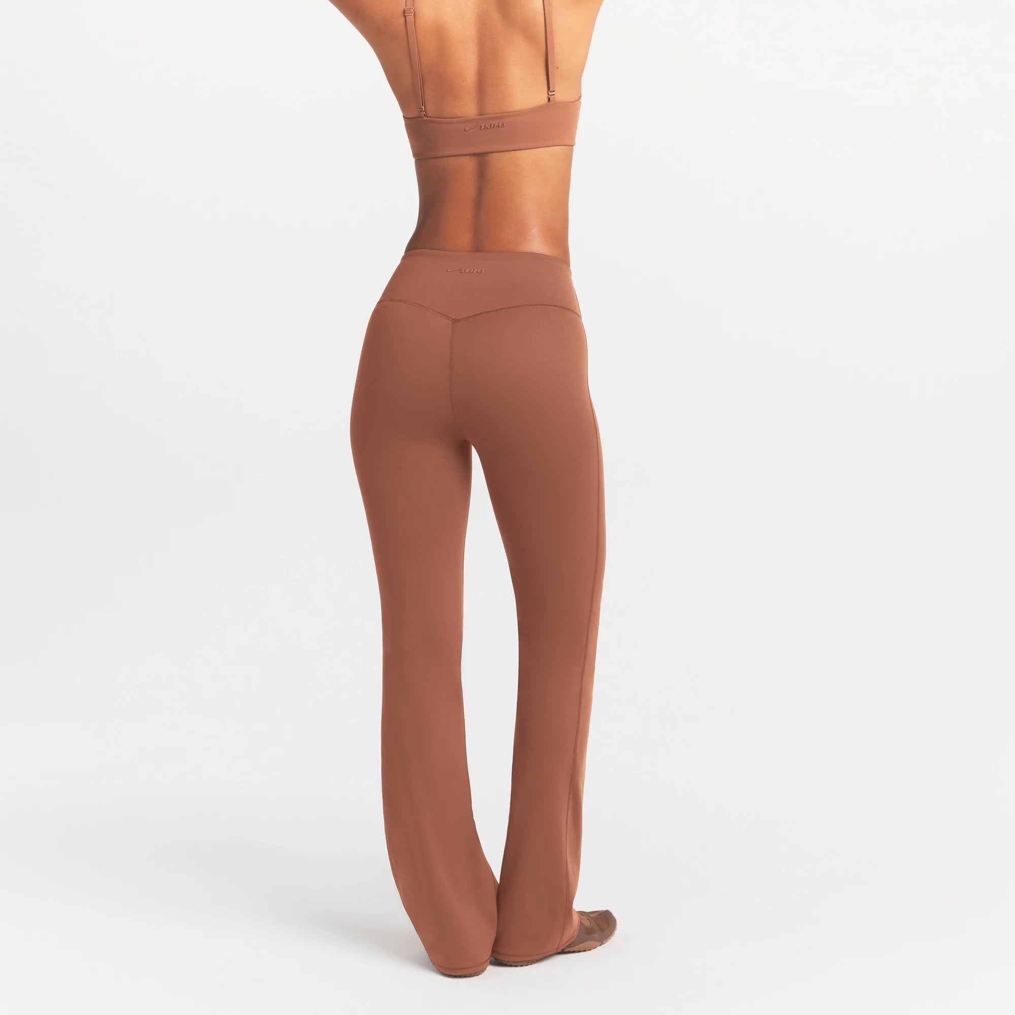 NikeSKIMS MATTE SLIM FLARE LEGGING | CAROB BROWN ON A MODEL SIDE VIEW @ | FOCUS: 0.0, 1.0, 0.9