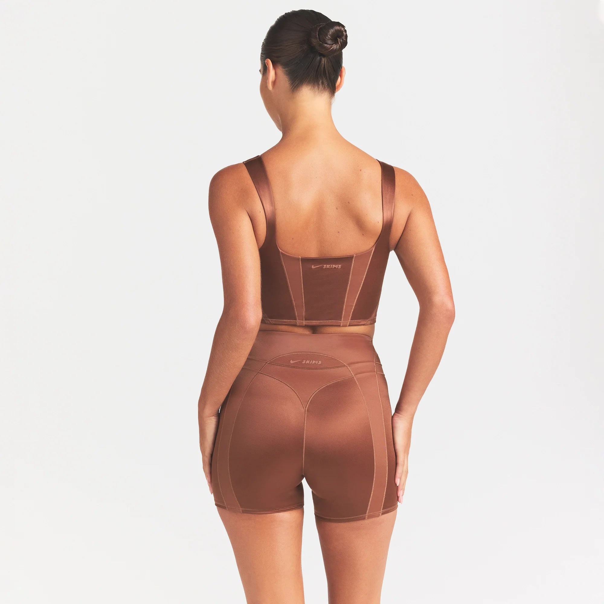 NikeSKIMS SATIN SHINE PANELED 5” BIKER SHORT | CAROB BROWN ON A MODEL SIDE VIEW @ | FOCUS: 0.0, 1.0, 0.9