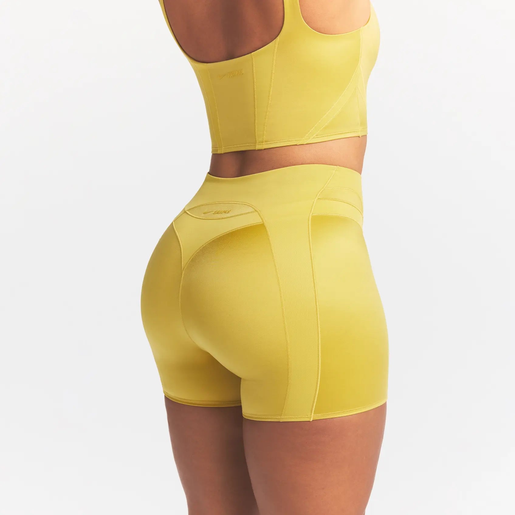 NikeSKIMS SATIN SHINE PANELED 5” BIKER SHORT | CITRINE ON A MODEL SIDE VIEW @ | FOCUS: 0.0, 1.0, 0.9