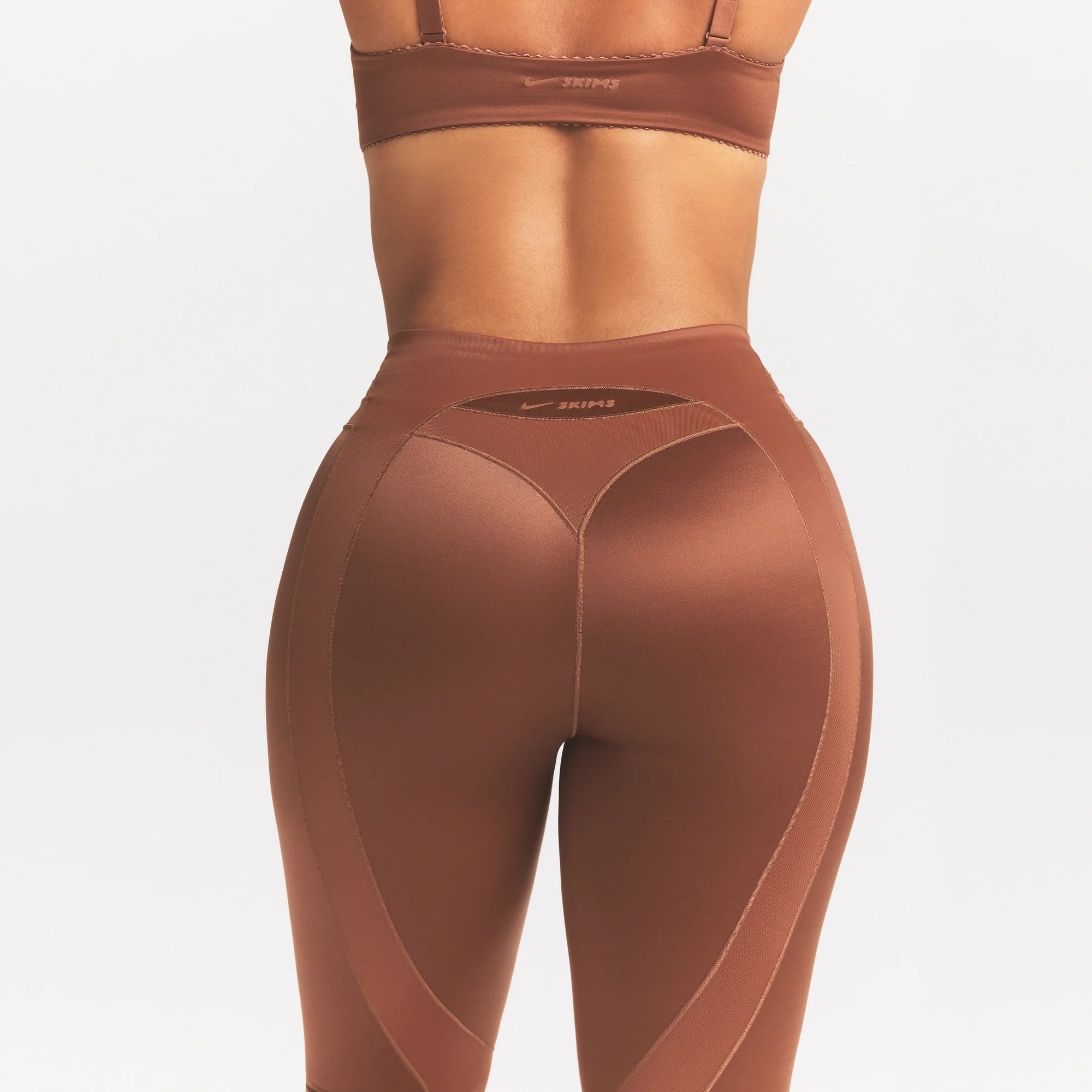 NikeSKIMS SATIN SHINE PANELED 26” LEGGING | CAROB BROWN ON A MODEL SIDE VIEW @ | FOCUS: 0.0, 1.0, 0.9