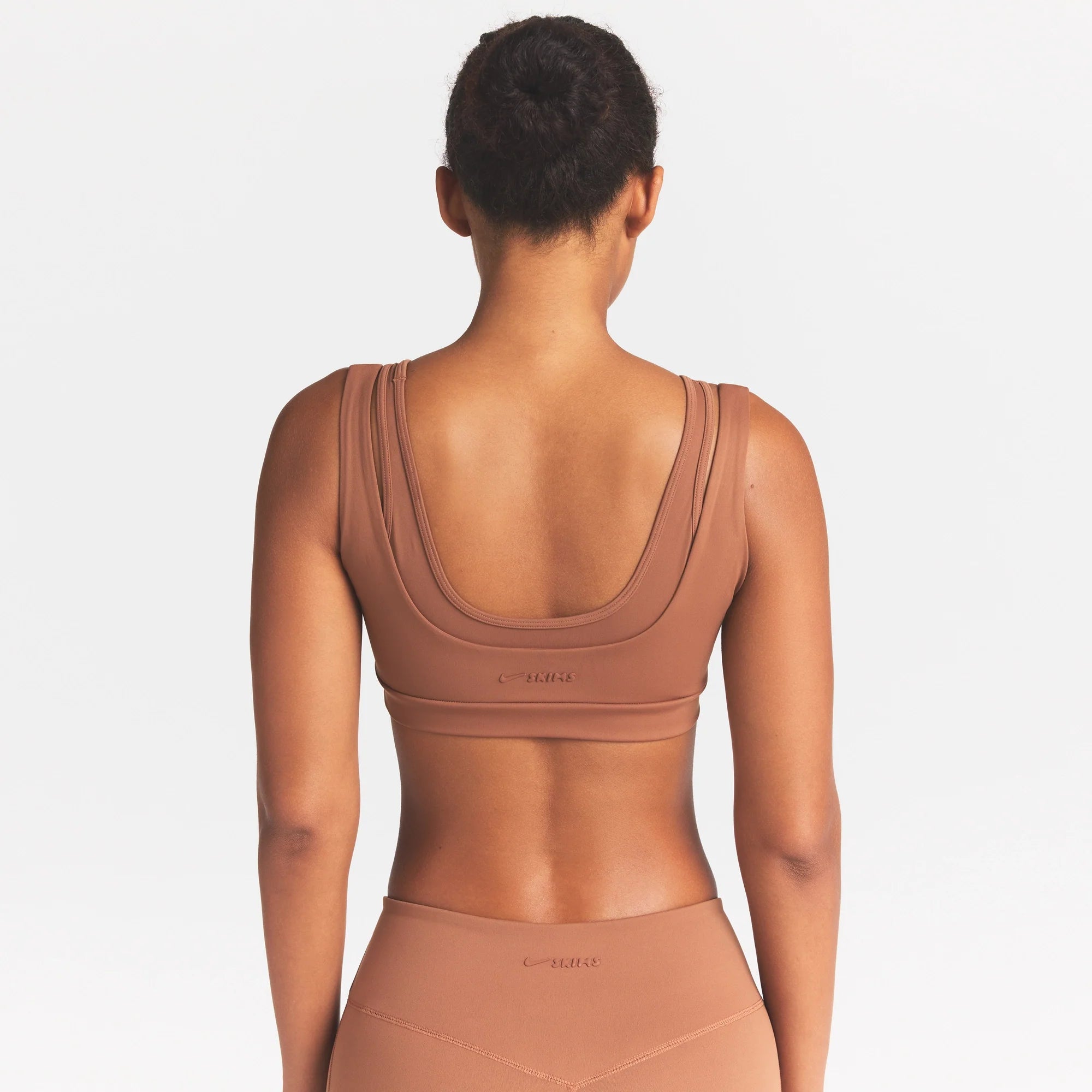 NikeSKIMS MATTE DOUBLE STRAP SCOOP BRA | CAROB BROWN ON A MODEL SIDE VIEW @ | FOCUS: 0.0, 1.0, 0.9