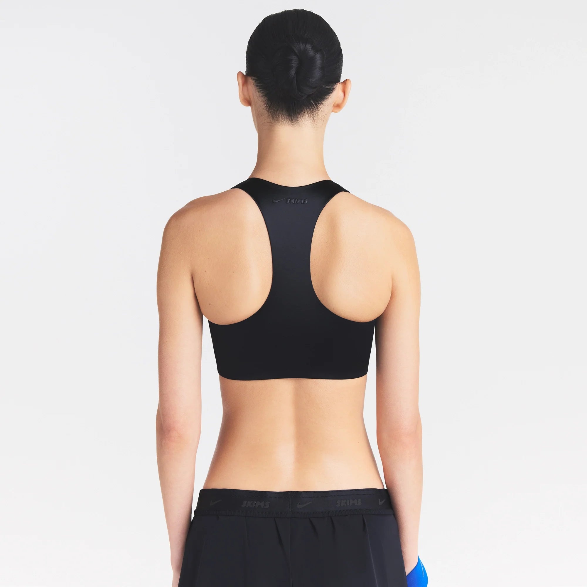 NikeSKIMS SATIN SHINE RACER BACK ZIP FRONT BRA | OBSIDIAN ON A MODEL SIDE VIEW @ | FOCUS: 0.0, 1.0, 0.9