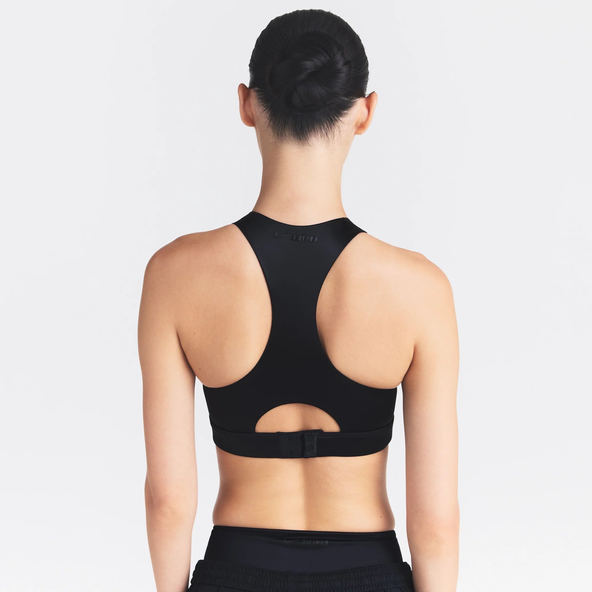 NikeSKIMS SATIN SHINE HIGH NECK BRA | OBSIDIAN ON A MODEL SIDE VIEW @ | FOCUS: 0.0, 1.0, 0.9