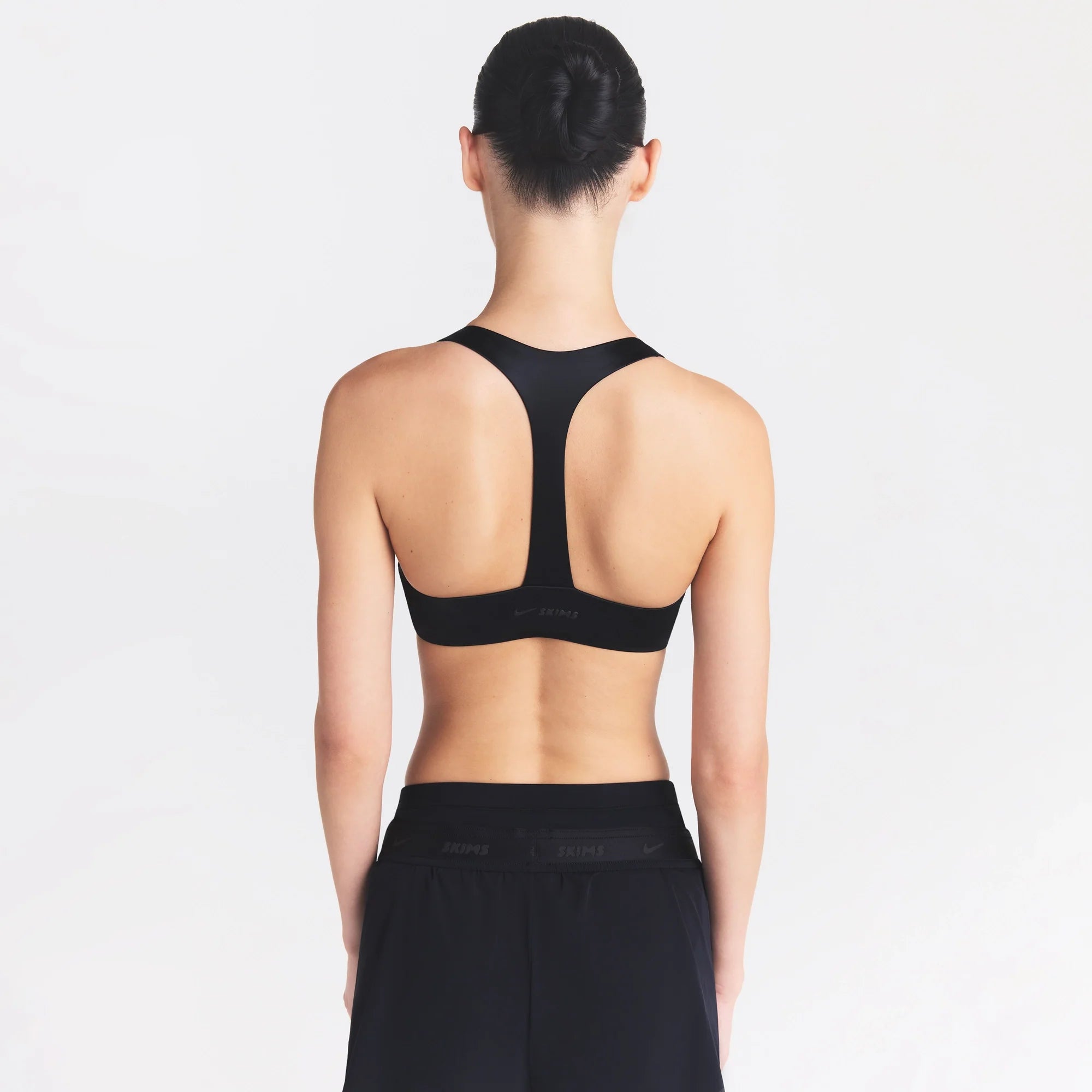 NikeSKIMS SATIN SHINE PLUNGE T-BACK BRA| OBSIDIAN ON A MODEL SIDE VIEW @ | FOCUS: 0.0, 1.0, 0.9