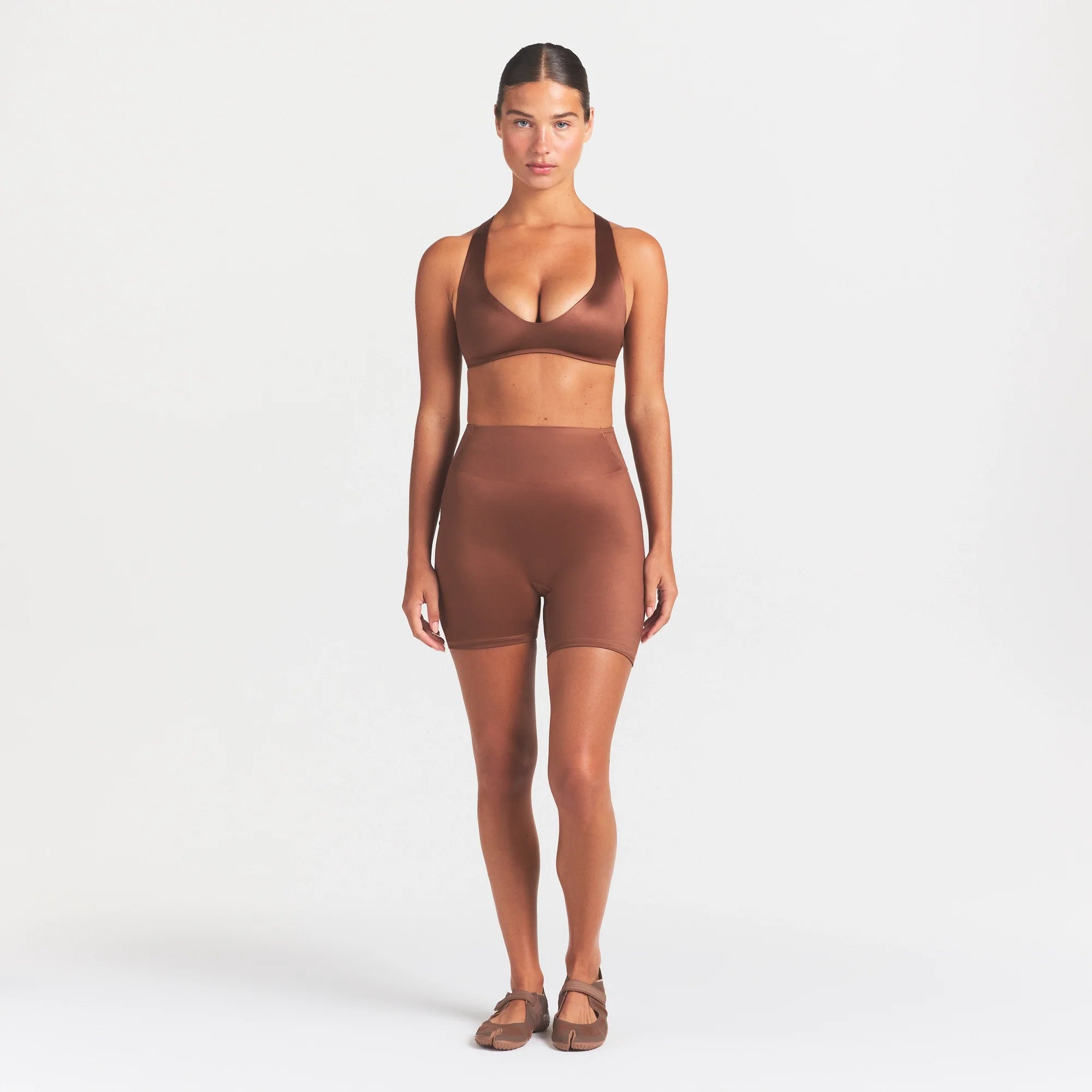 NikeSKIMS SATIN SHINE PLUNGE T-BACK BRA | CAROB BROWN ON A MODEL FRONT VIEW @ | FOCUS: 0.0, 1.0, 0.9