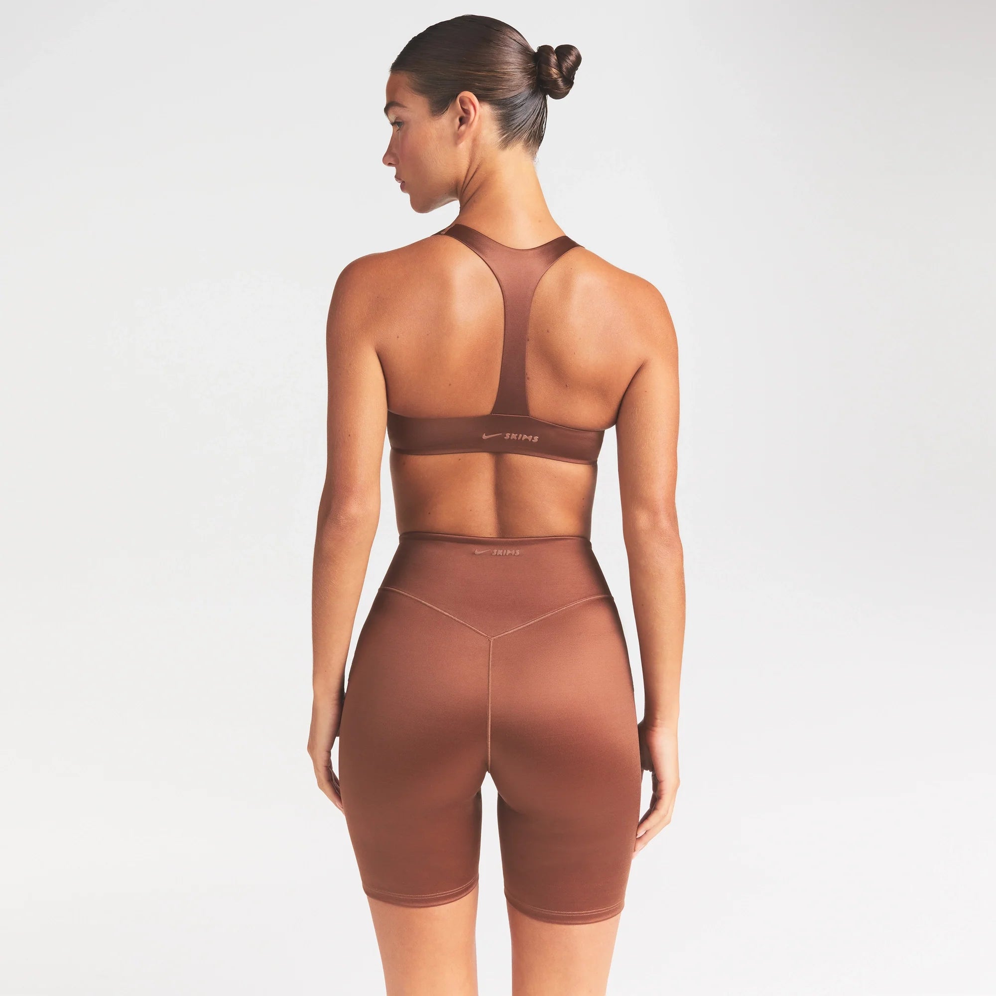 NikeSKIMS SATIN SHINE PLUNGE T-BACK BRA | CAROB BROWN ON A MODEL SIDE VIEW @ | FOCUS: 0.0, 1.0, 0.9