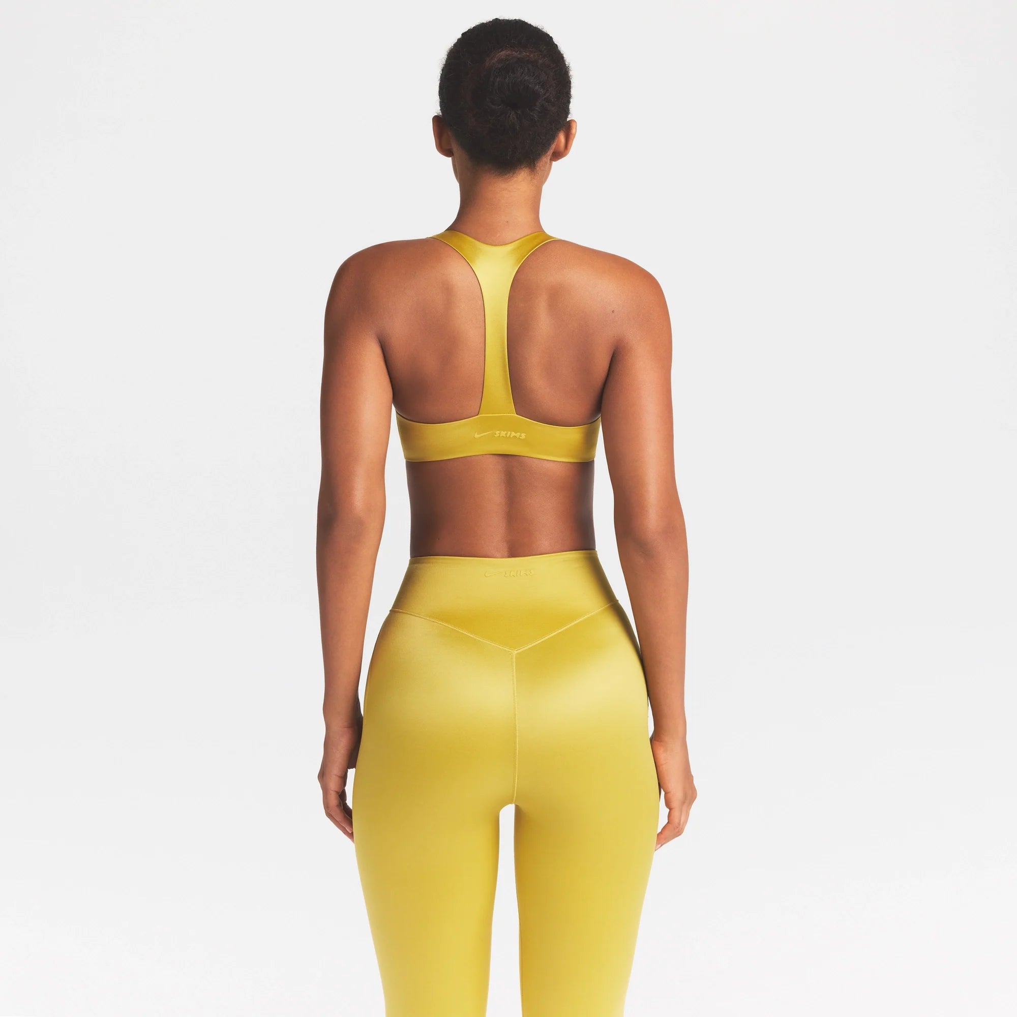 NikeSKIMS SATIN SHINE PLUNGE T-BACK BRA | CITRINE ON A MODEL SIDE VIEW @ | FOCUS: 0.0, 1.0, 0.9