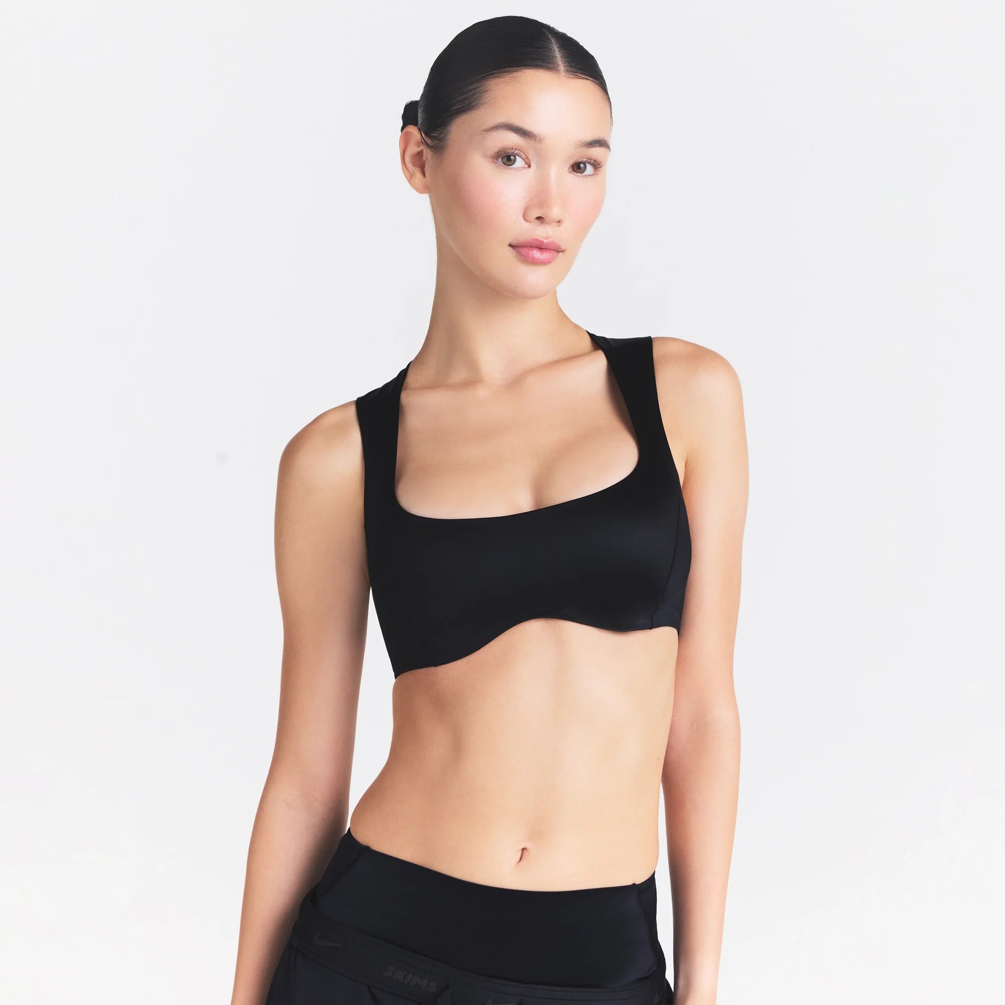NikeSKIMS SATIN SHINE WIDE SCOOP BRA | OBSIDIAN ON A MODEL SIDE VIEW @ | FOCUS: 0.0, 1.0, 0.9