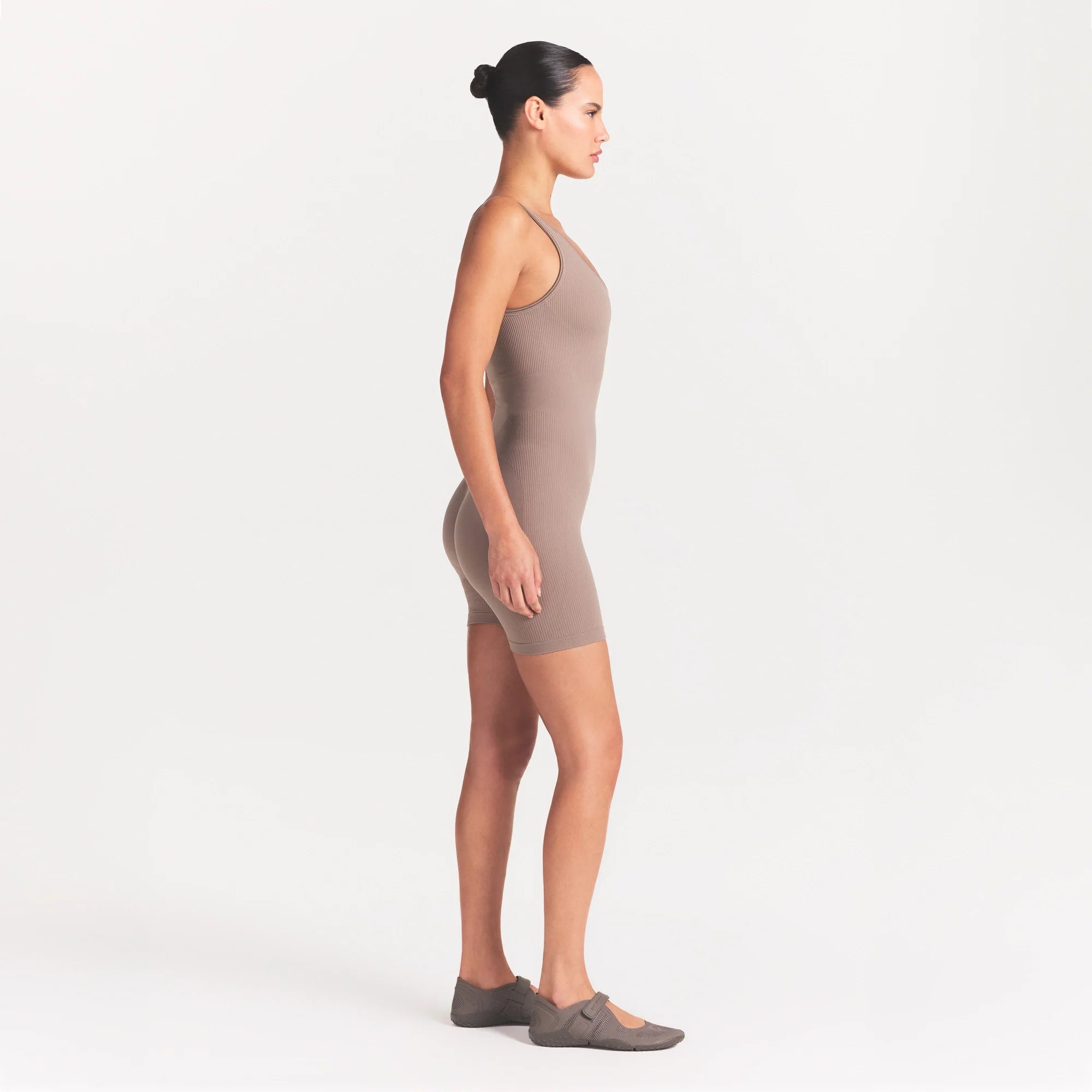 NikeSKIMS RIBBED SEAMLESS SCOOP 5" ONE PIECE | DRIFTWOOD ON A MODEL SIDE VIEW @ | FOCUS: 0.0, 1.0, 0.9