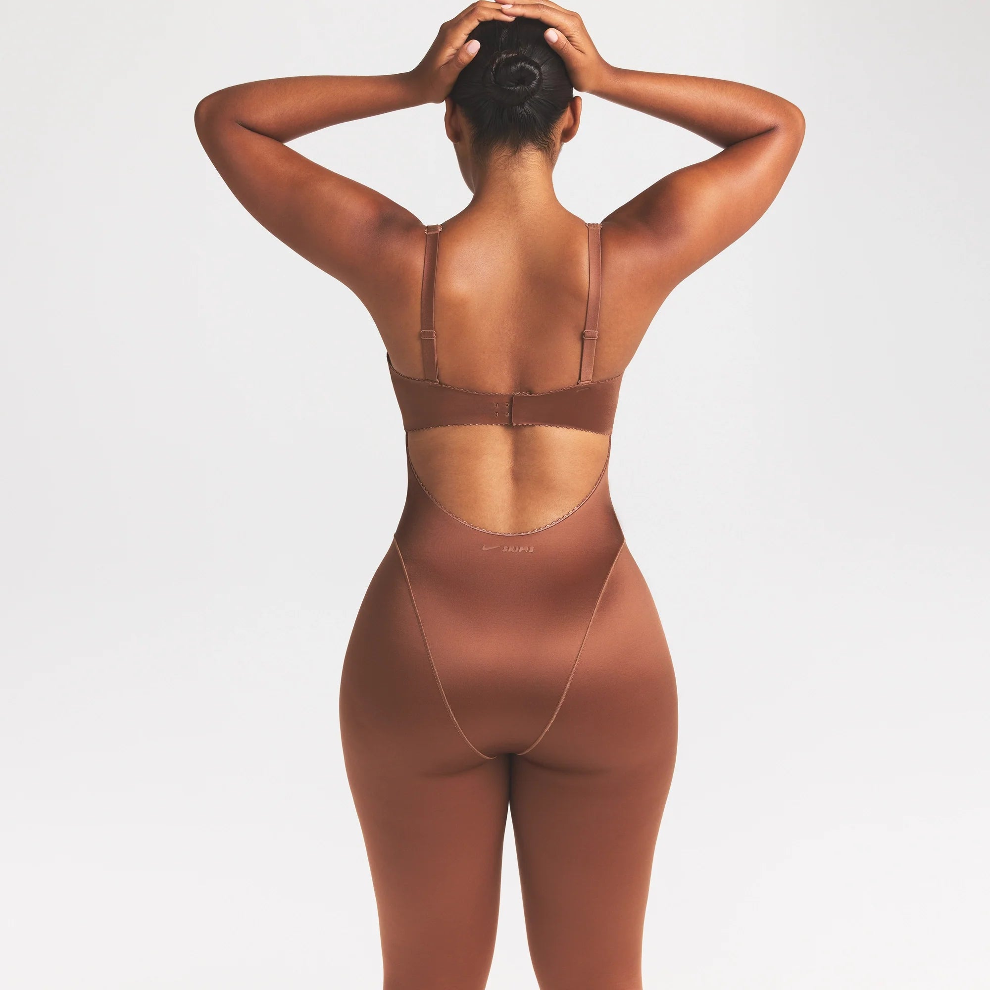 NikeSKIMS SATIN SHINE PANELED 26" ONE PIECE | CAROB BROWN ON A MODEL SIDE VIEW