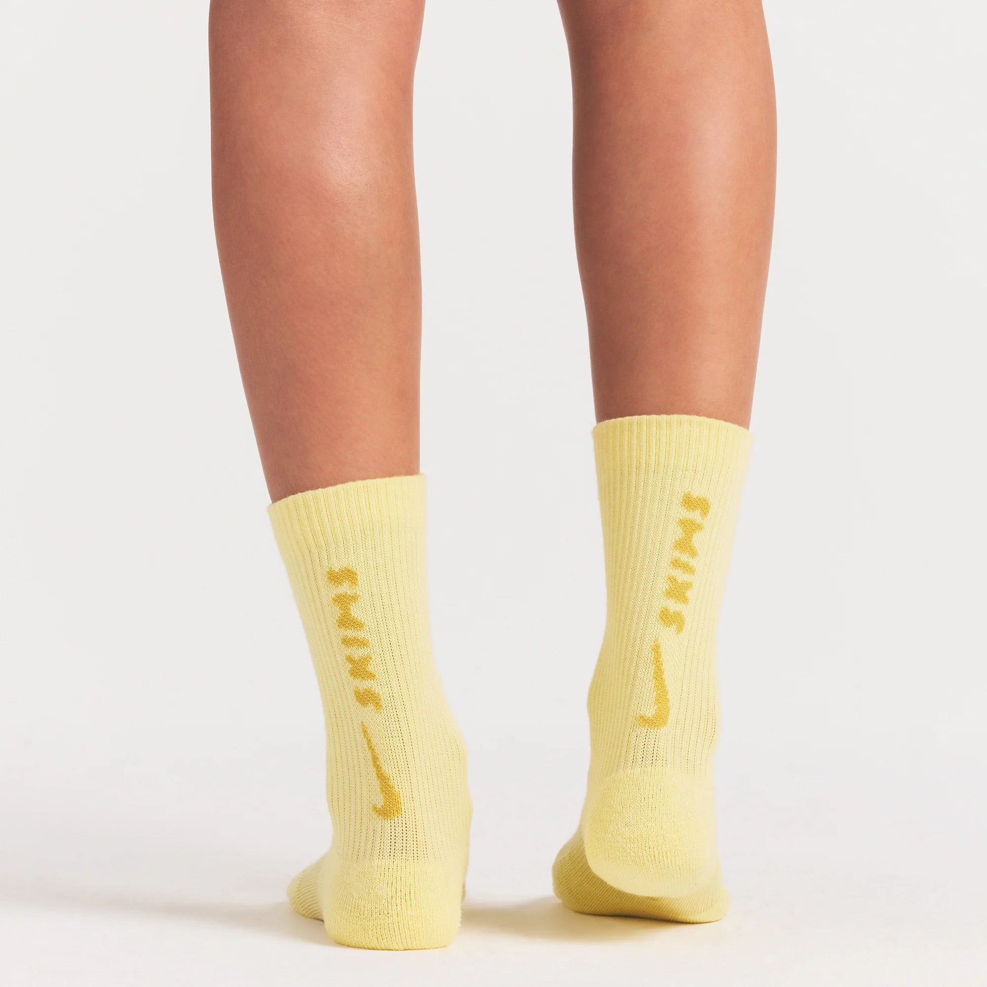 NikeSKIMS ACCESSORIES DRI-FIT™ CREW SOCK 3-PACK | DRIFTWOOD/TALC/BICYCLE YELLOW ON A MODEL SIDE VIEW