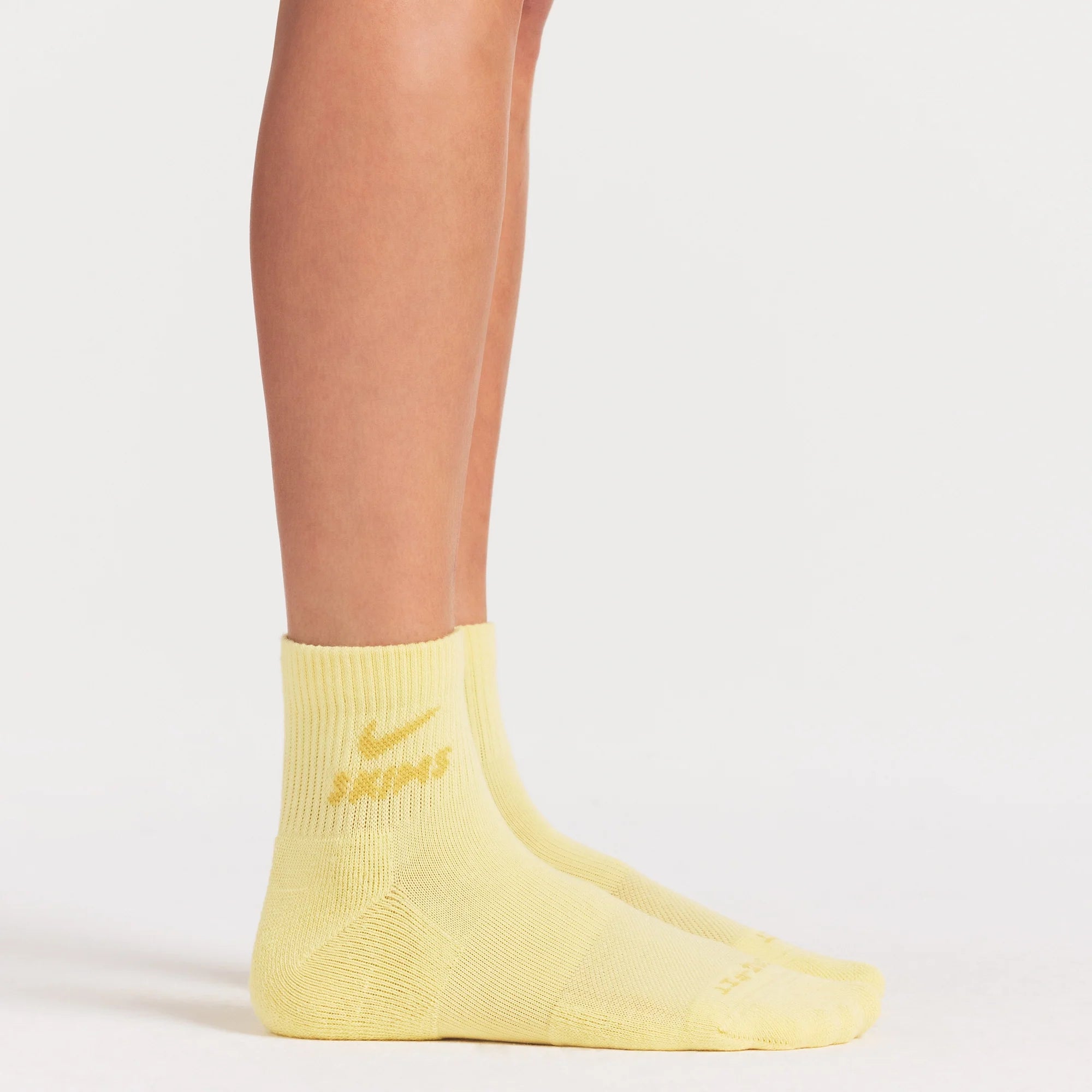 NikeSKIMS ACCESSORIES DRI-FIT™ QUARTER CREW SOCK 3-PACK | DRIFTWOOD/TALC/BICYCLE YELLOW ON A MODEL SIDE VIEW @ | FOCUS: 0.0, 1.0, 0.9